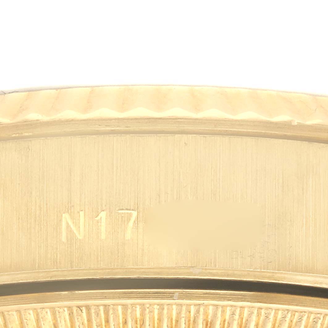 The image shows a close-up of the side of a Rolex President 69178 Women's Yellow Gold Black Dial 69178 Women's Yellow Gold Black Dial model watch, highlighting the bezel and part of the serial engraving.