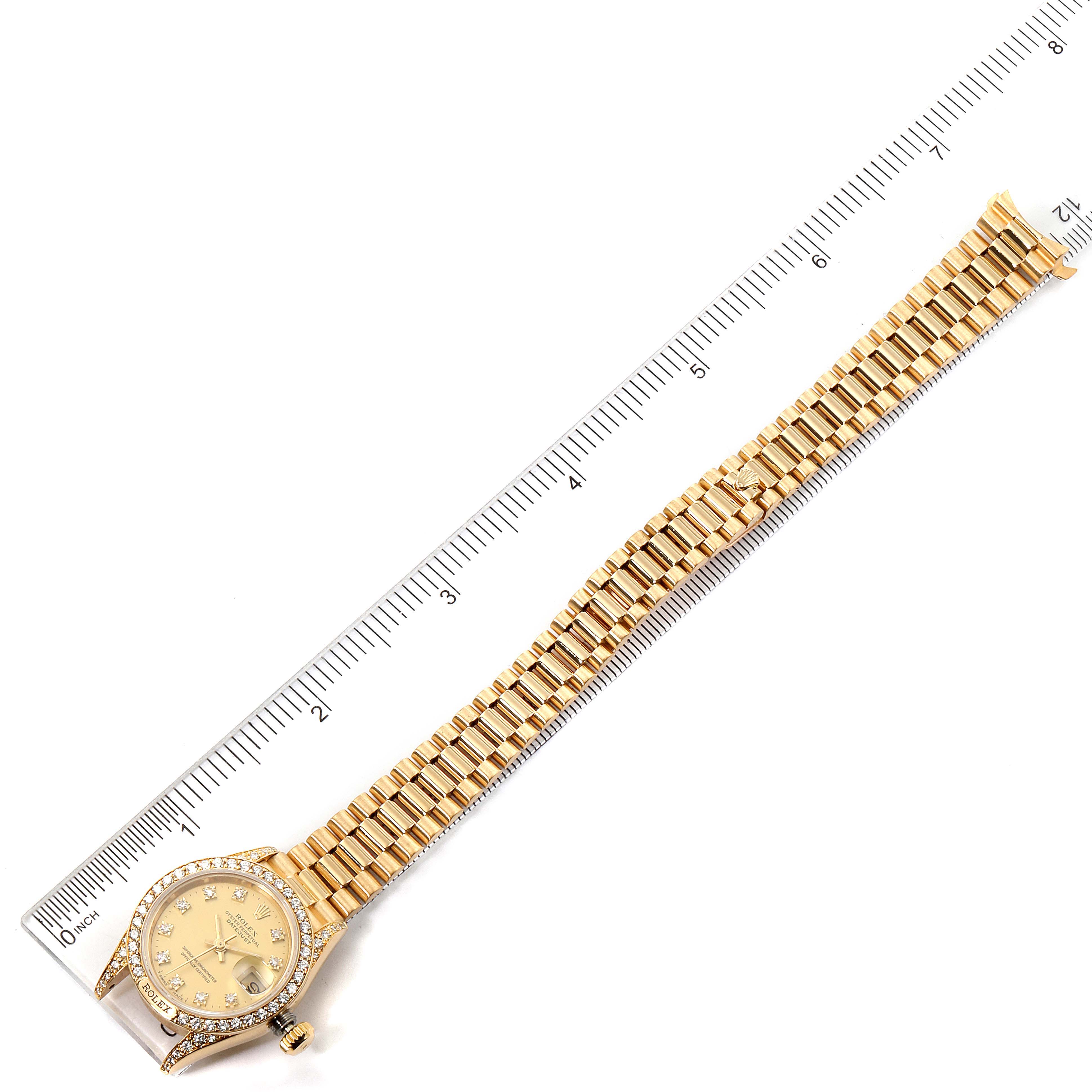 The image shows a top-down view of a Rolex President 69158 Women
s Yellow Gold Champagne Dial 69158 Women
s Yellow Gold Champagne Dial model watch with a ruler for scale.