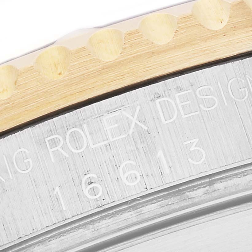 This image shows a partial close-up of the bezel and case of a Rolex Submariner 16613 Men
s Steel and Gold (two tone) Blue Dial 16613 Men
s Steel and Gold (two tone) Blue Dial watch, highlighting its model engraving.