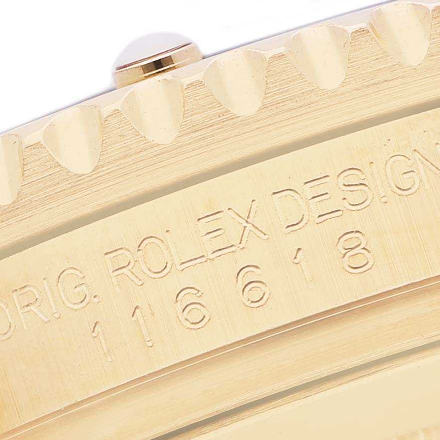 The image shows a close-up of the bezel and engraved design markings on a Rolex Submariner 116618LN Men's Yellow Gold Black Dial model.