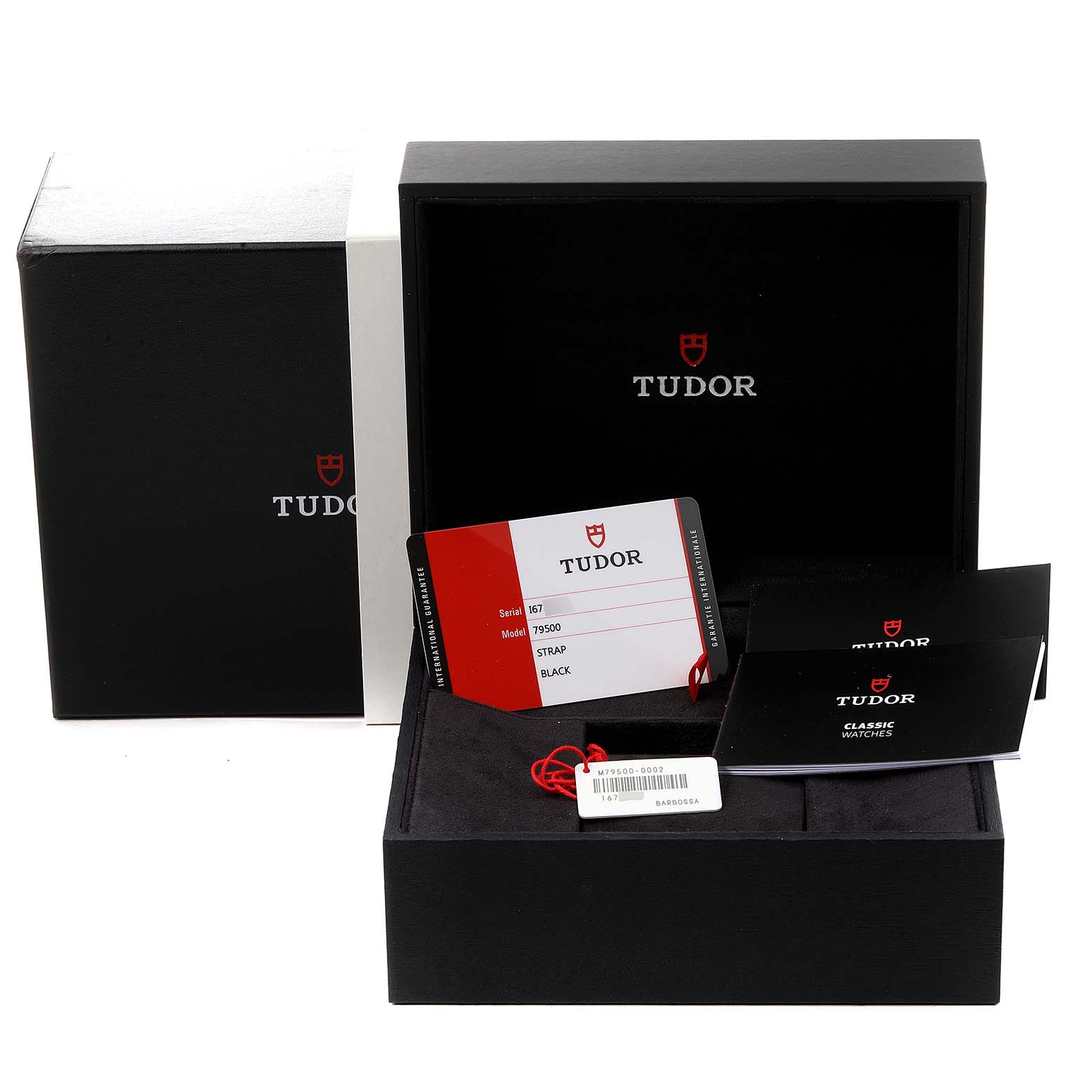 The image shows the packaging, certification card, tags, and manuals for the Heritage Black Bay model by Tudor, presented at an angle displaying the open box with accessories.