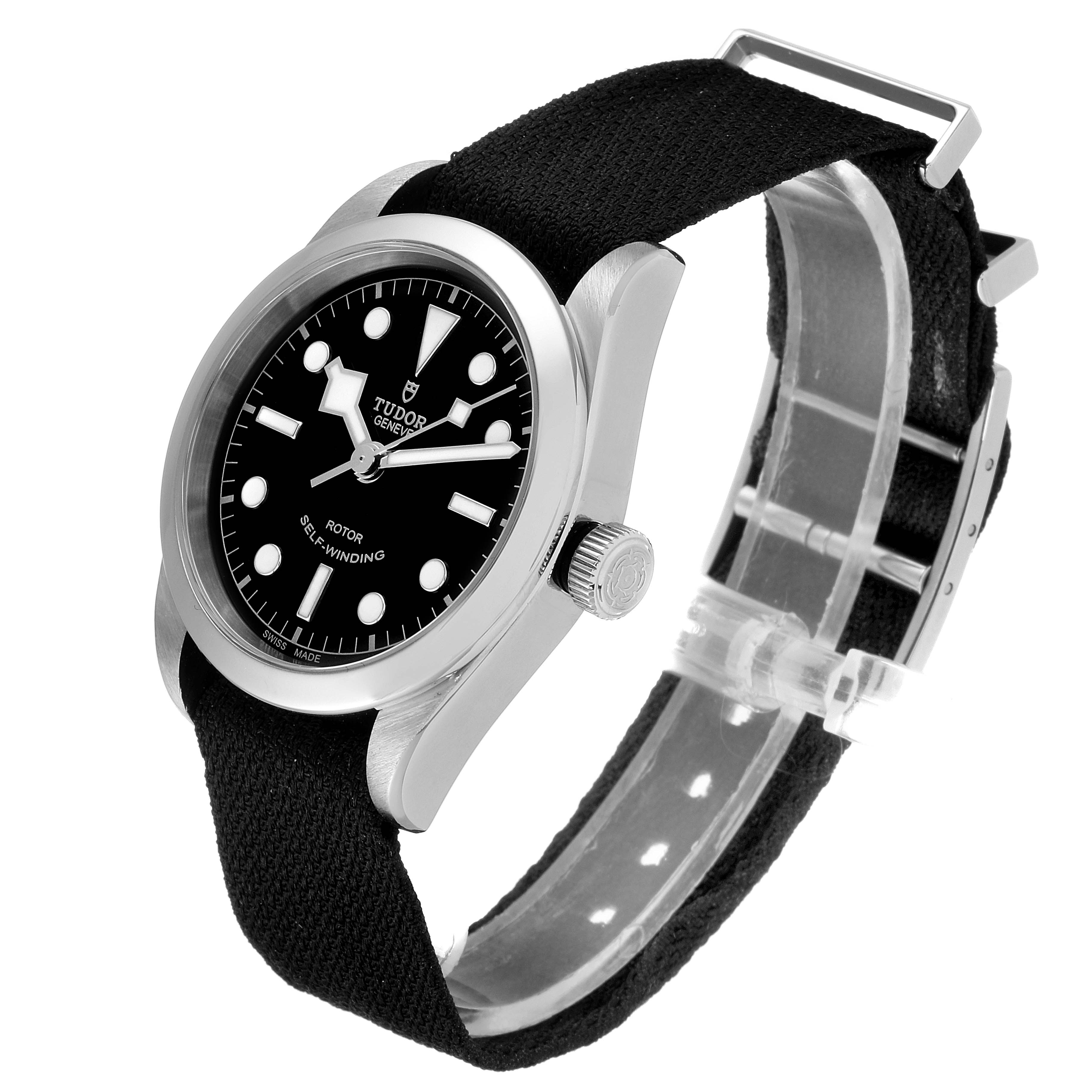 The Tudor Heritage Black Bay 79500 Men
s Stainless Steel Black Dial 79500 Men
s Stainless Steel Black Dial watch is shown from a perspective angle, highlighting its face, crown, and fabric strap.