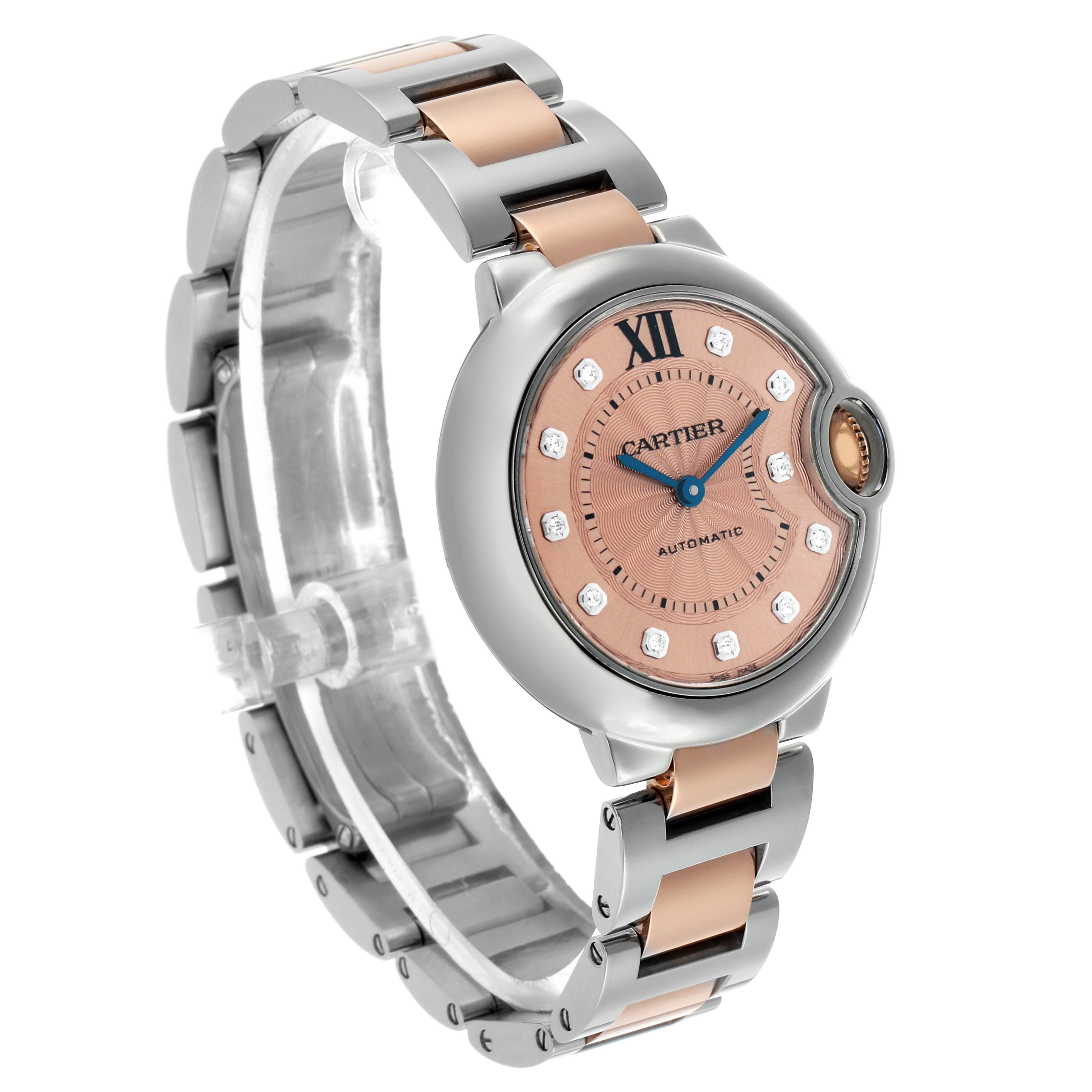 The Cartier Ballon Bleu WE902053 Women's Stainless Steel Pink Dial watch is shown at a slight angle, revealing its face, metal bracelet, and rounded crown detail.