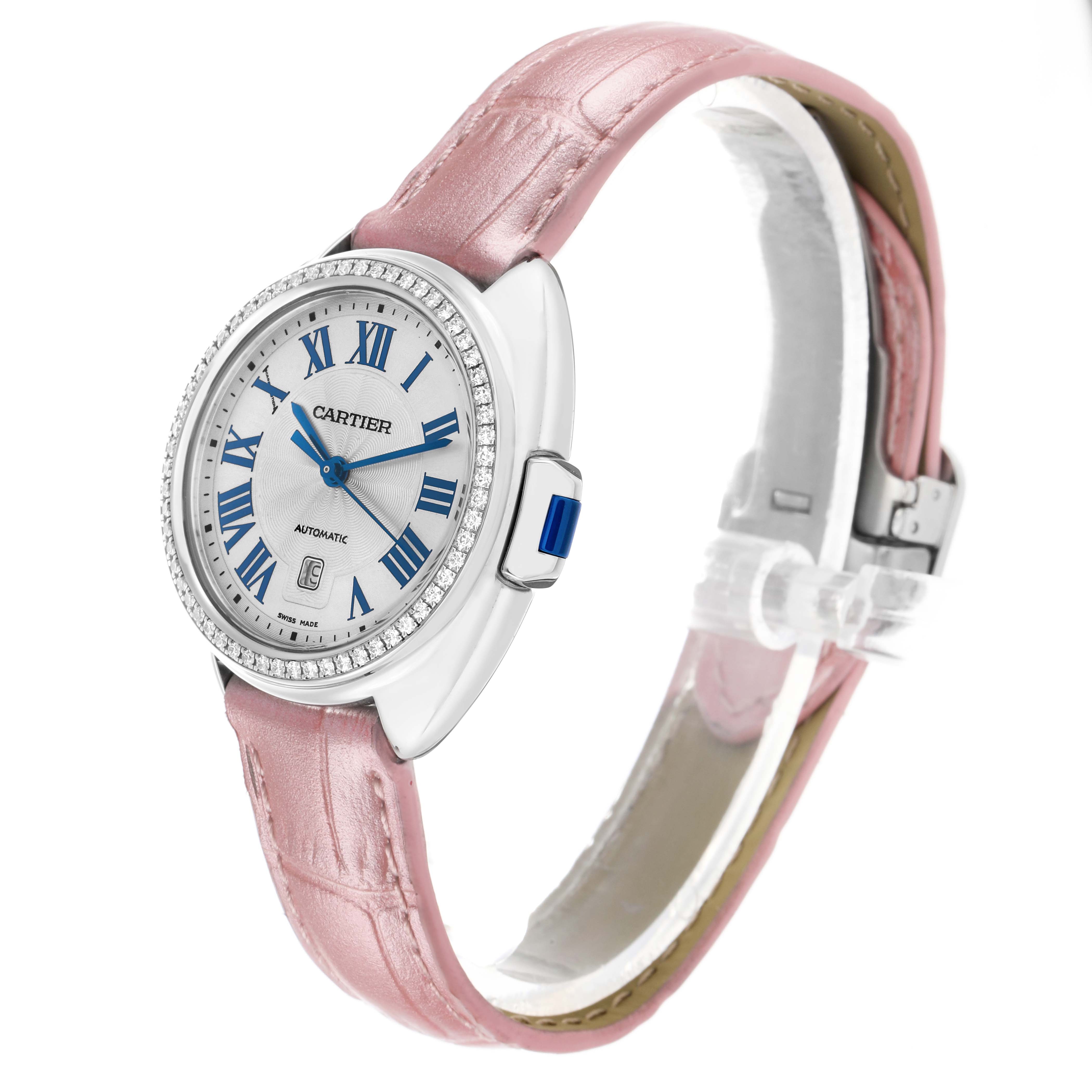 The Cartier Clé watch is shown at an angled side view, displaying the face, pink strap, and the blue-accented crown.