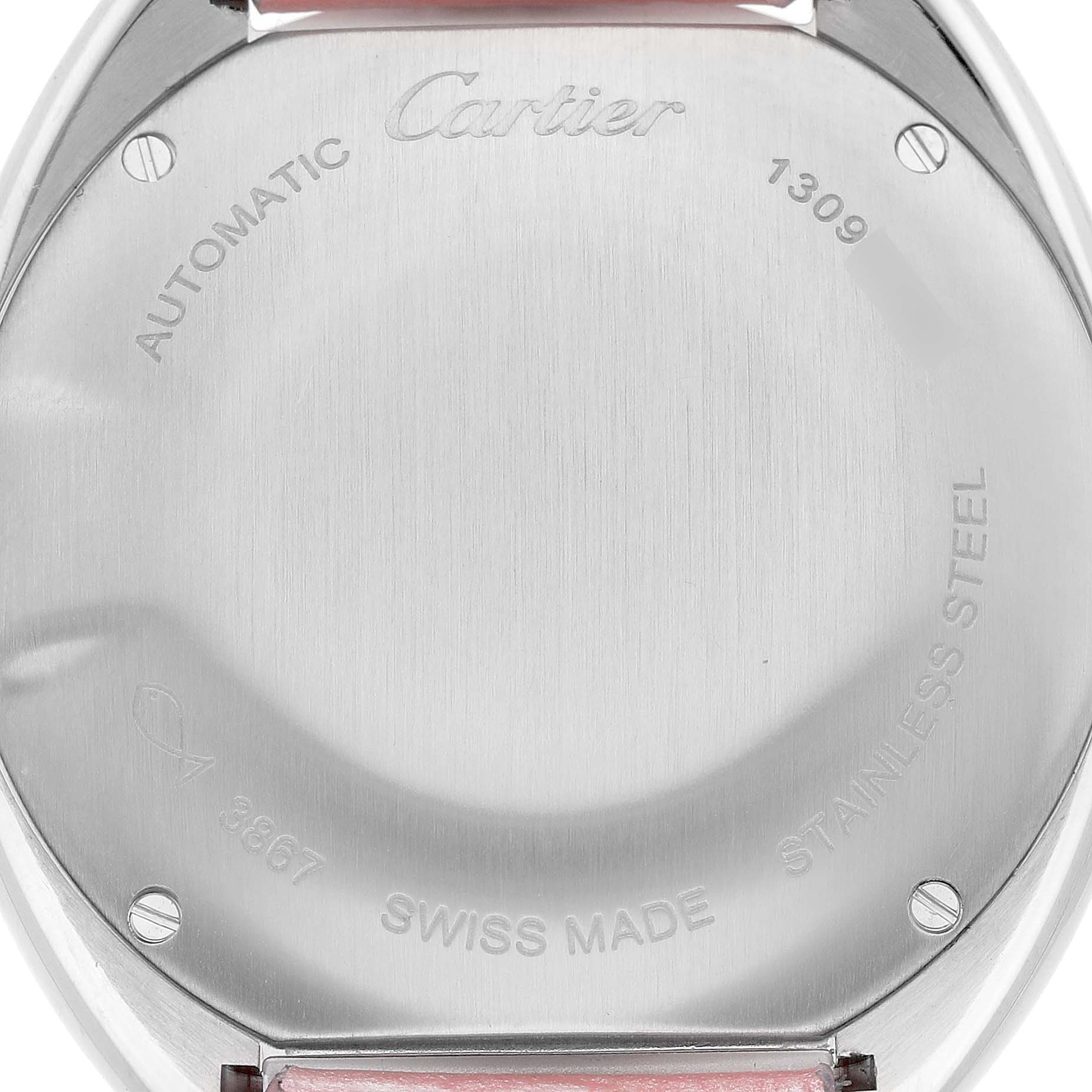 The image shows the back of a Cartier Clé watch, displaying engravings and stainless steel with a pink strap partially visible.