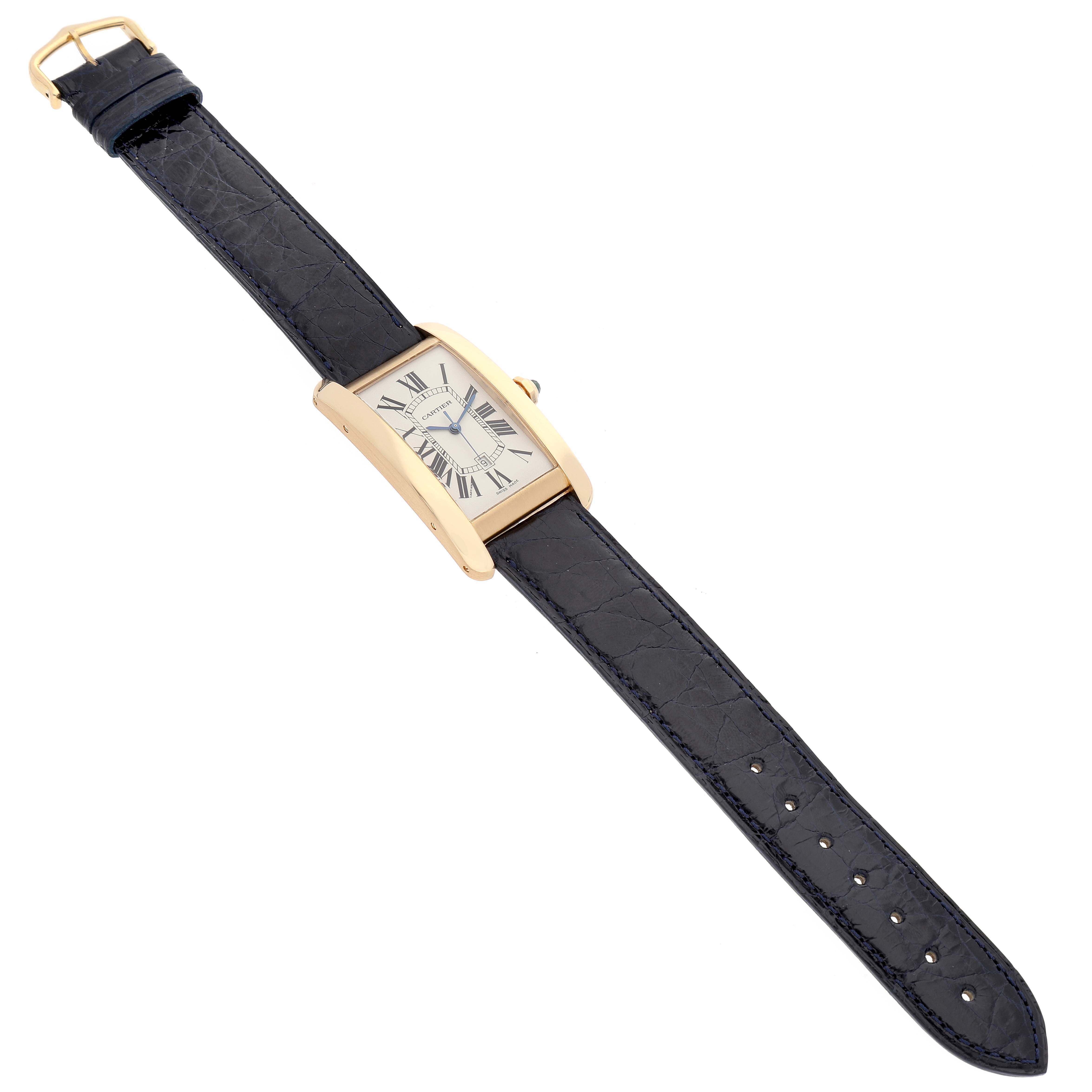 This is a full view of a Cartier Tank Americaine W2603156 Men's Yellow Gold Silver Dial W2603156 Men's Yellow Gold Silver Dial watch, showcasing its black leather strap and rectangular gold case.