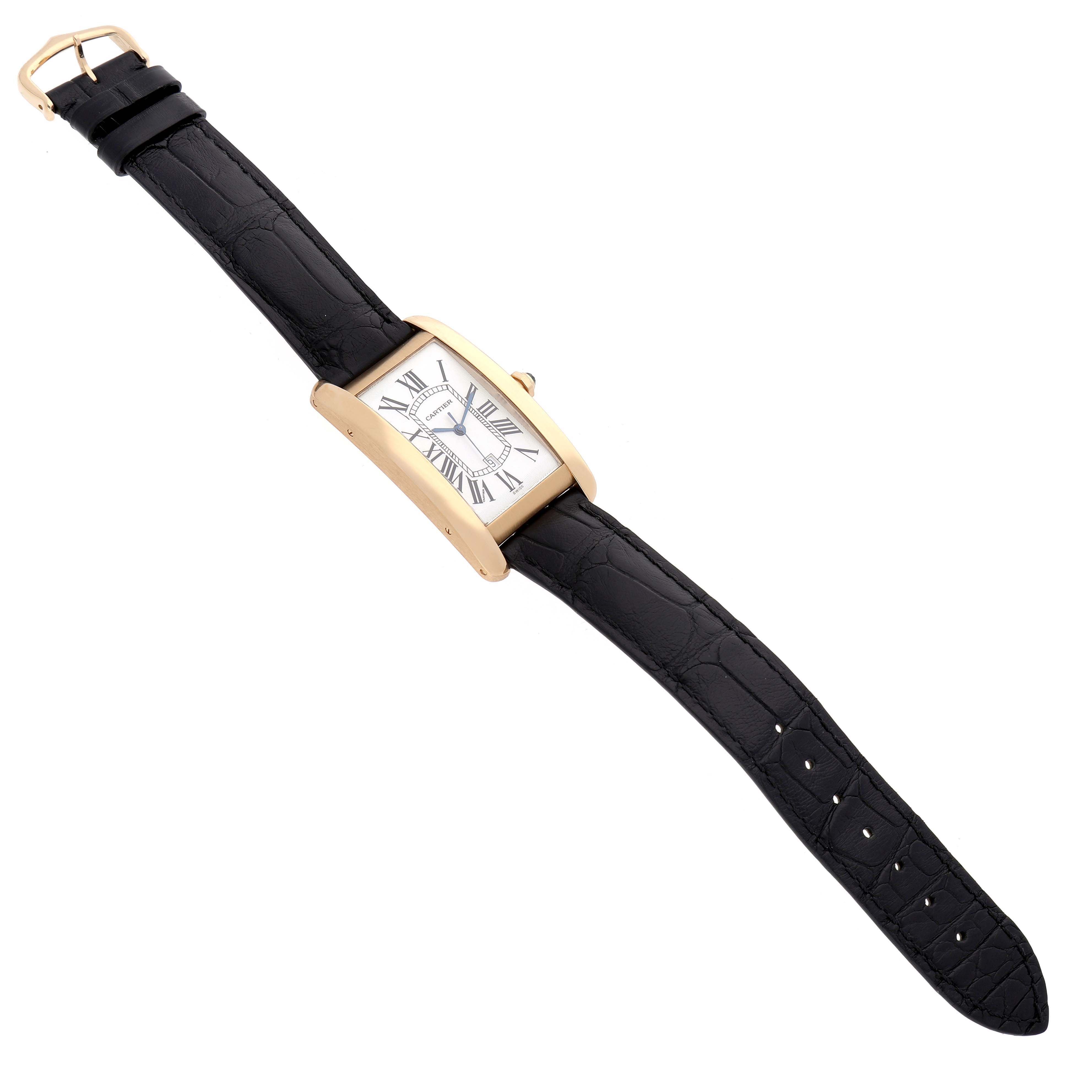 The Cartier Tank Americaine W2603156 Men's Yellow Gold Silver Dial watch is shown at a slight angle, displaying its rectangular face, Roman numerals, and black leather strap.