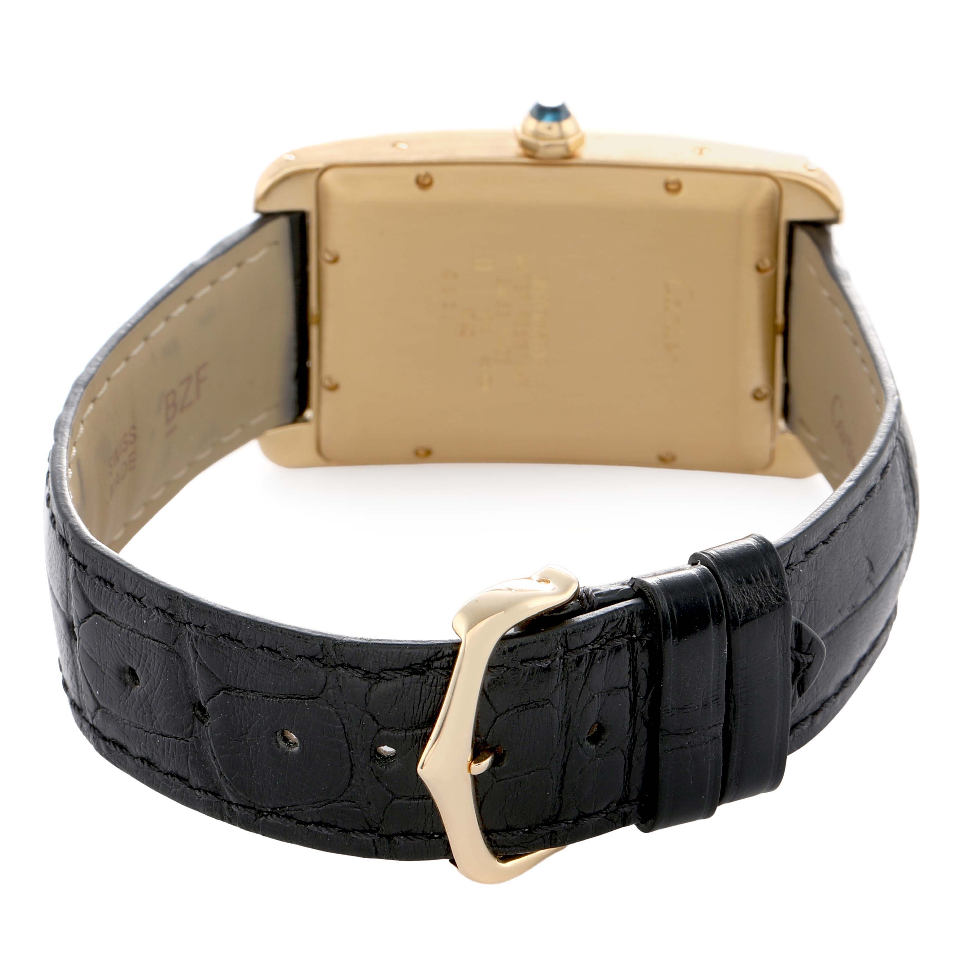 The image shows the back view of a Cartier Tank Americaine W2603156 Men's Yellow Gold Silver Dial watch, highlighting the case, strap, and buckle.