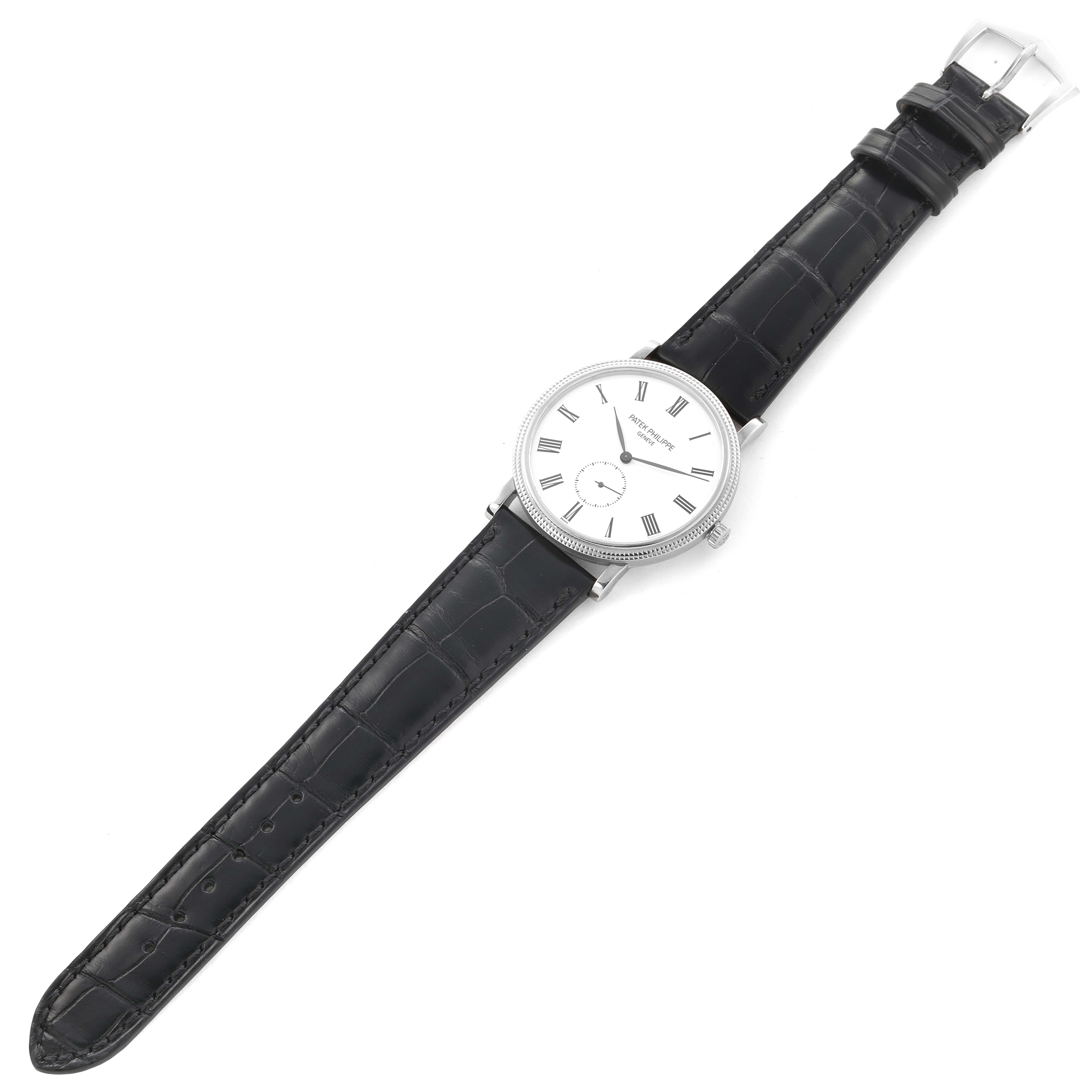 The Patek Philippe Calatrava 5116G-001 Men's White Gold White Dial 5116G-001 Men's White Gold White Dial watch is shown from a top-down angle, highlighting the face, strap, and buckle.