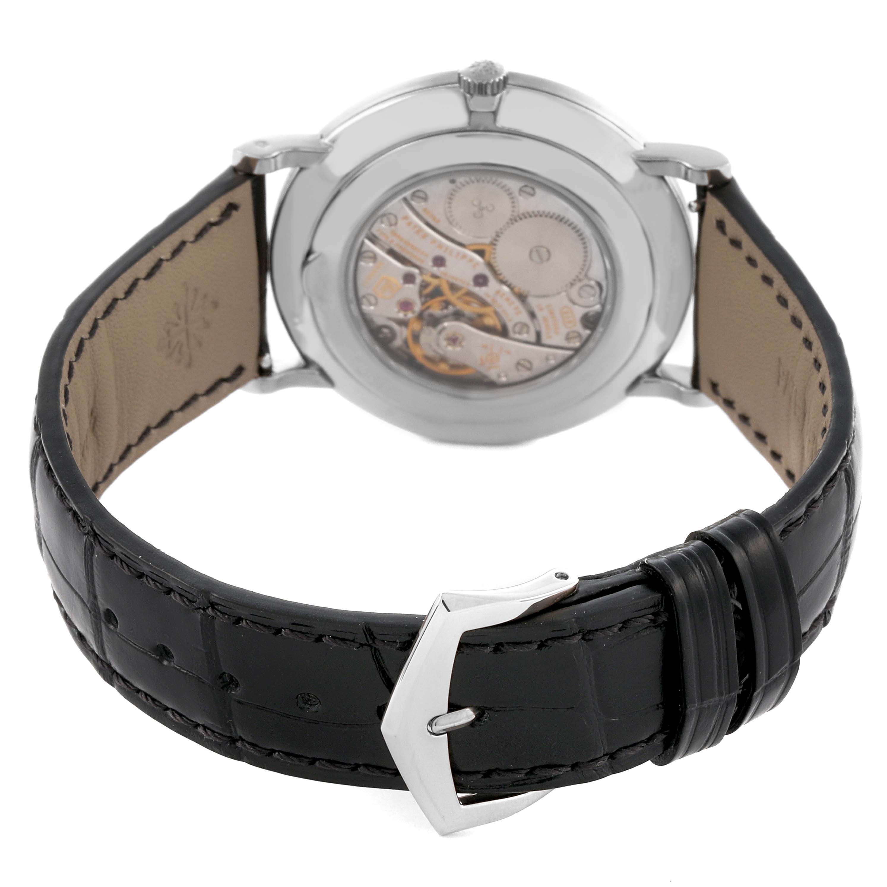 The Patek Philippe Calatrava 5116G-001 Men's White Gold White Dial 5116G-001 Men's White Gold White Dial watch is shown from the back, highlighting the movement through the transparent case and the leather strap.