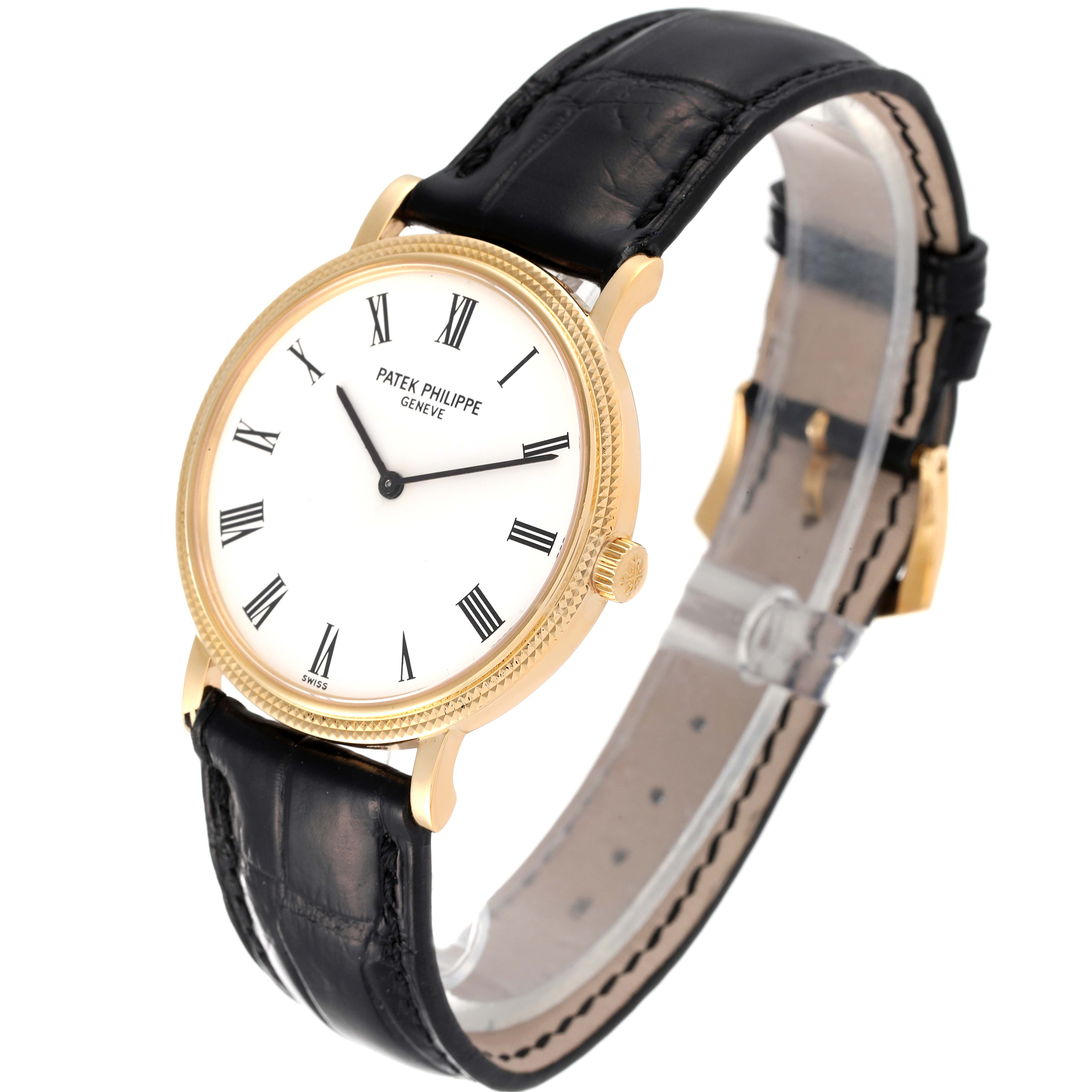 The image shows a Patek Philippe Calatrava 5120J Men's Yellow Gold White Dial 5120J Men's Yellow Gold White Dial watch from a front-side angle, highlighting its white dial, black leather strap, and gold case.