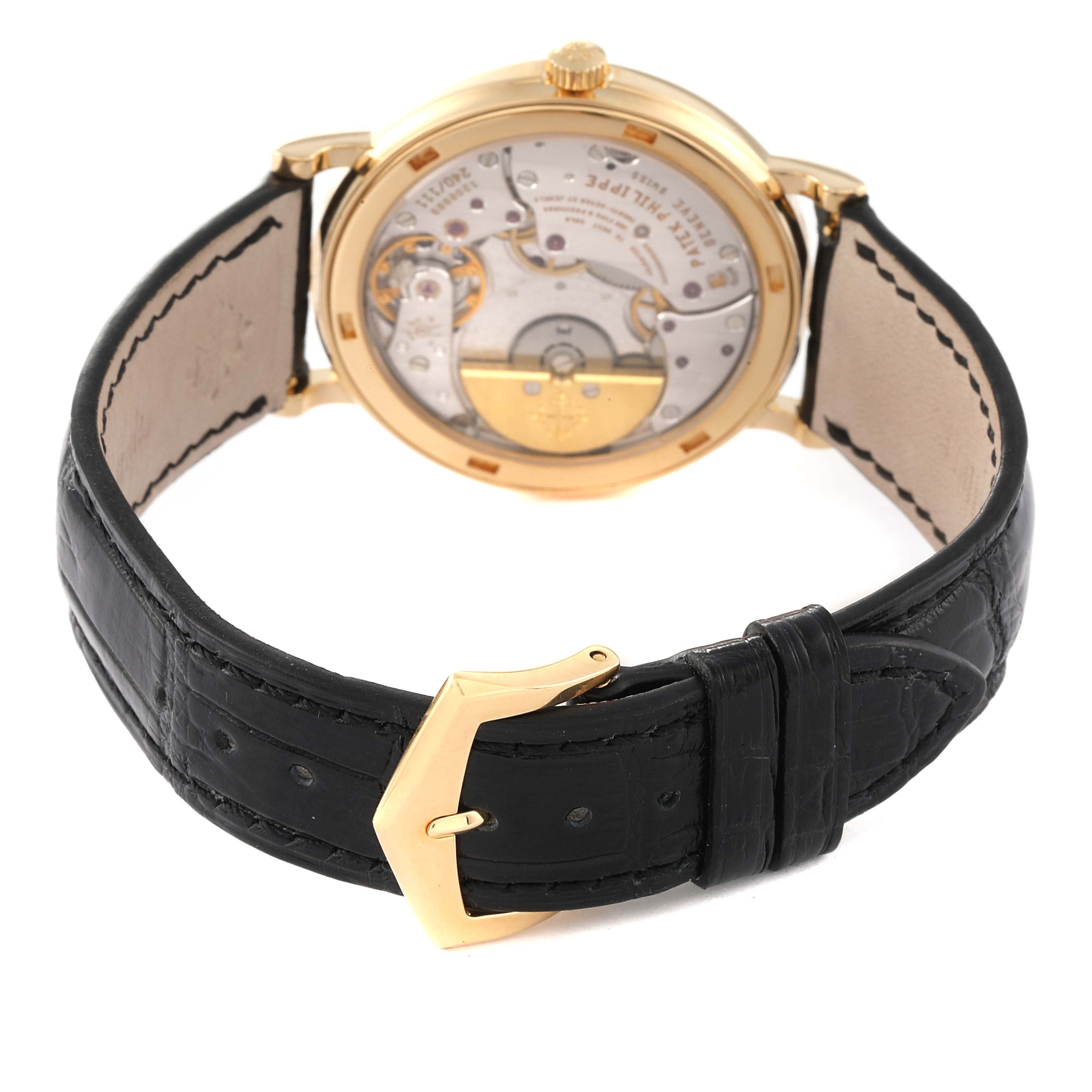 This image shows the back view of a Patek Philippe Calatrava 5120J Men's Yellow Gold White Dial 5120J Men's Yellow Gold White Dial watch with visible movement and a black leather strap.