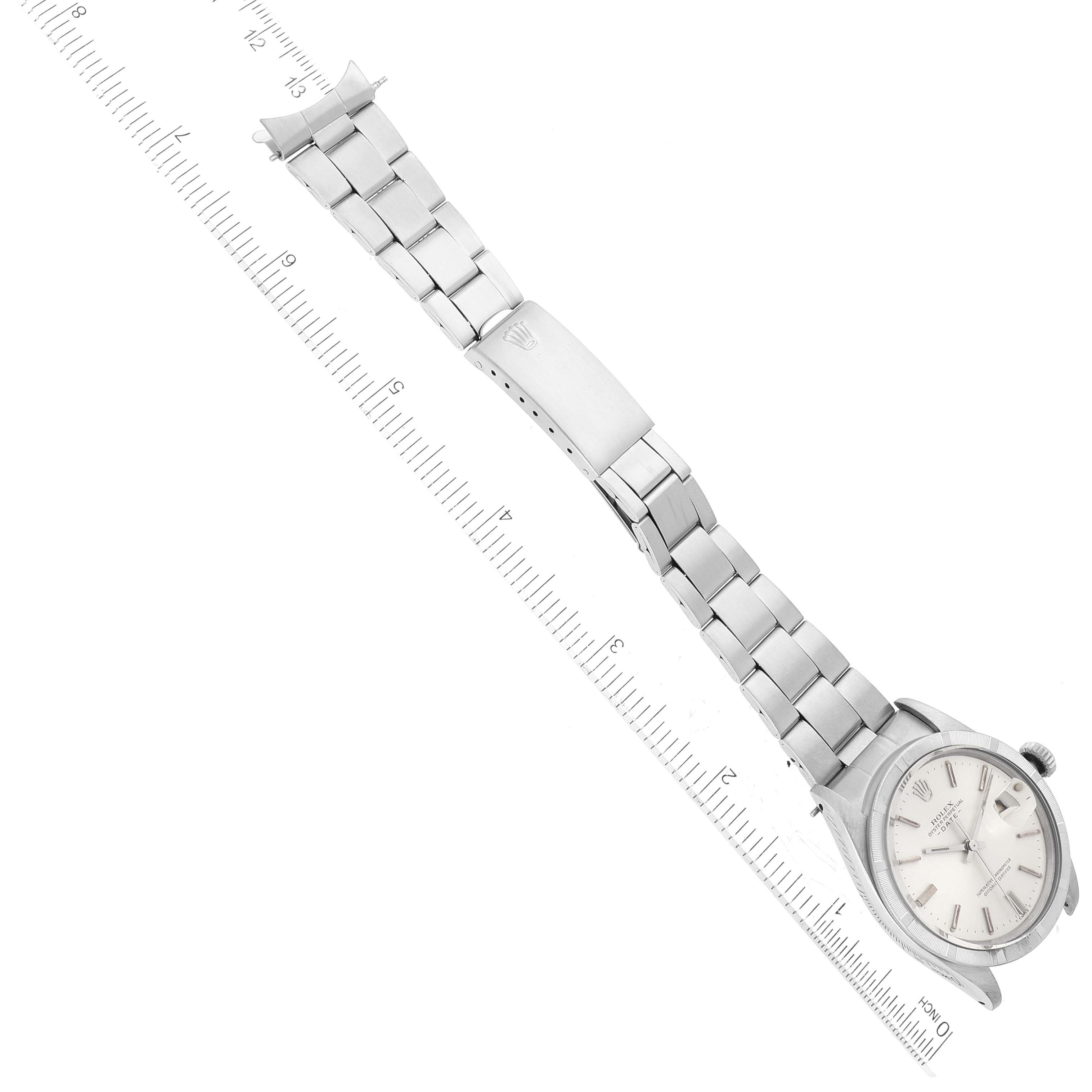 The image shows an aerial view of a Rolex Vintage Collection 1501 Men's Stainless Steel Silver Dial 1501 Men's Stainless Steel Silver Dial watch with visible dial, case, bracelet, and clasp alongside a ruler.