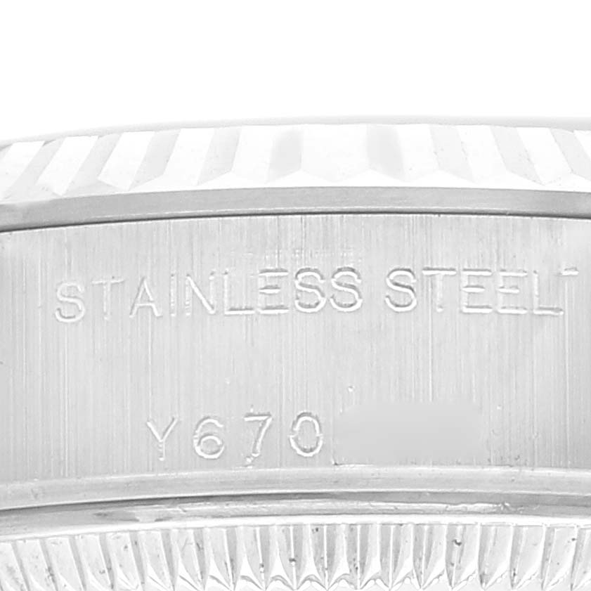 This image shows a close-up of the side of a stainless steel Rolex Datejust 79174 Women's Stainless Steel Black Dial 79174 Women's Stainless Steel Black Dial watch with parts of its casing and serial number visible.