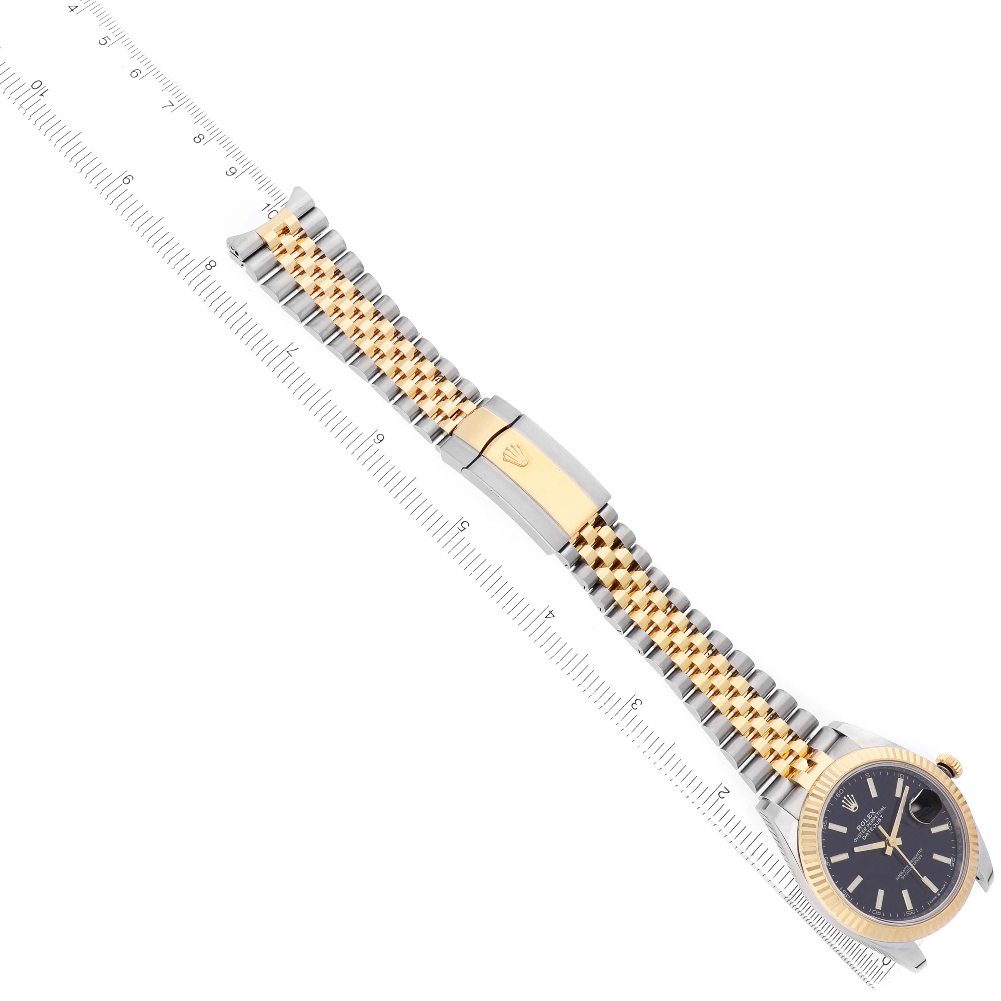 The Rolex Datejust 41 126333 Men's Steel and Gold (two tone) Black Dial watch is angled diagonally, showing its face, two-tone bracelet, and clasp, placed next to a ruler.