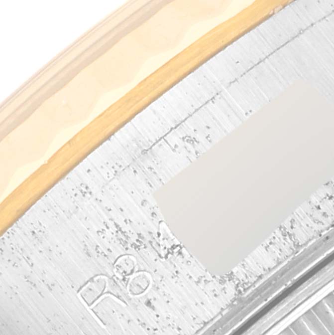 This close-up image shows part of the engraved bezel and fluted crown of a Rolex Datejust 69173 Women's Steel and Gold (two tone) Black Dial 69173 Women's Steel and Gold (two tone) Black Dial watch.