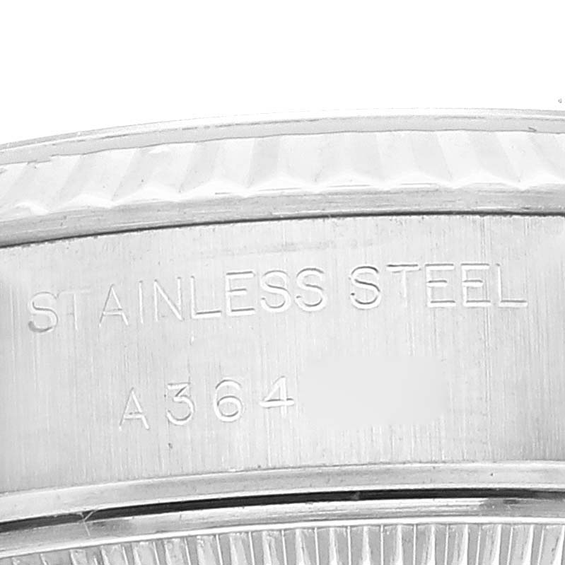 This image shows a close-up of the side of a Rolex Datejust 79174 Women's Stainless Steel Pink Dial 79174 Women's Stainless Steel Pink Dial watch, specifically highlighting the stainless steel casing and engraved text.