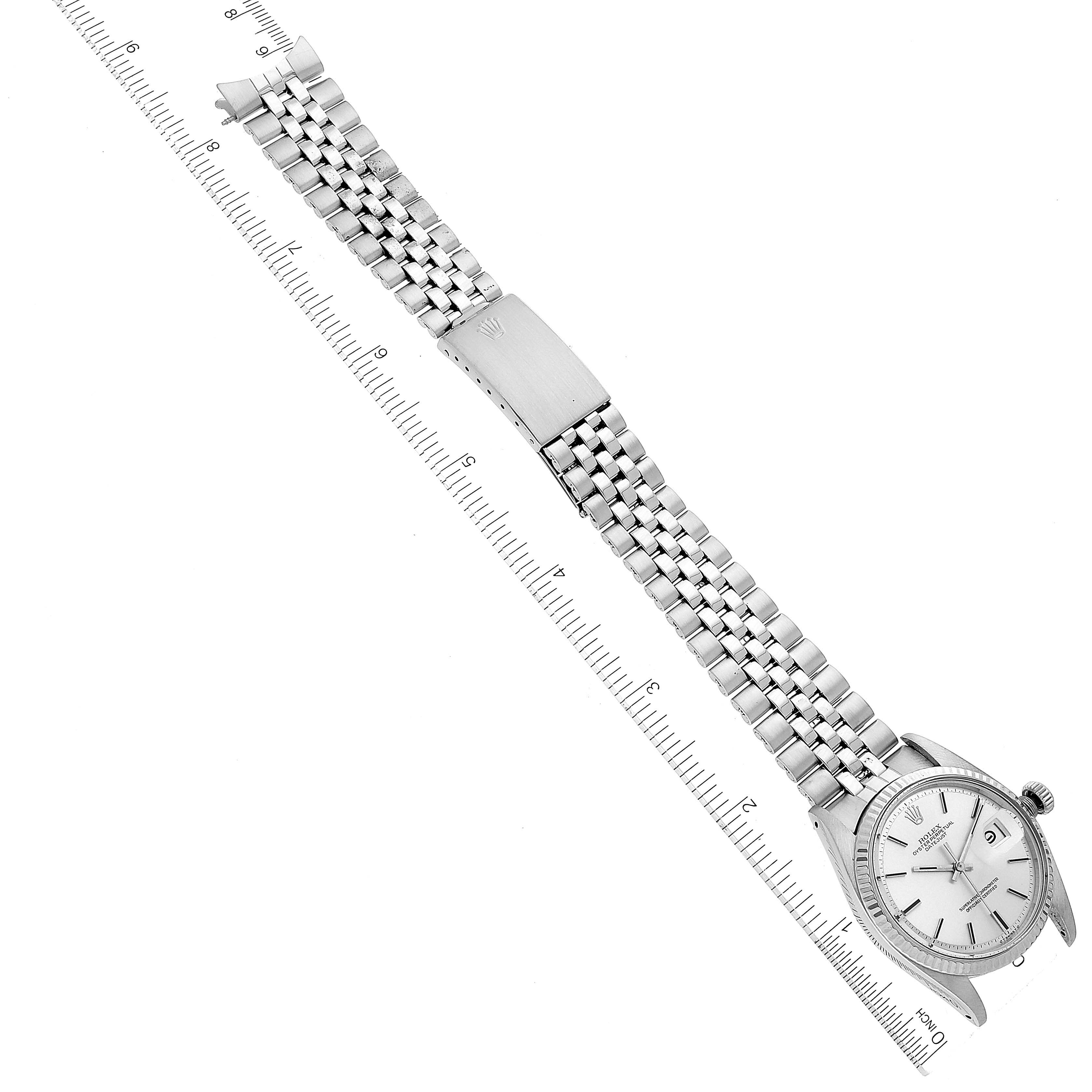 The image shows a top-down view of the Rolex Vintage Collection 1601 Men
s Stainless Steel Silver Dial 1601 Men
s Stainless Steel Silver Dial watch with its full metal bracelet and clasp displayed alongside a ruler.