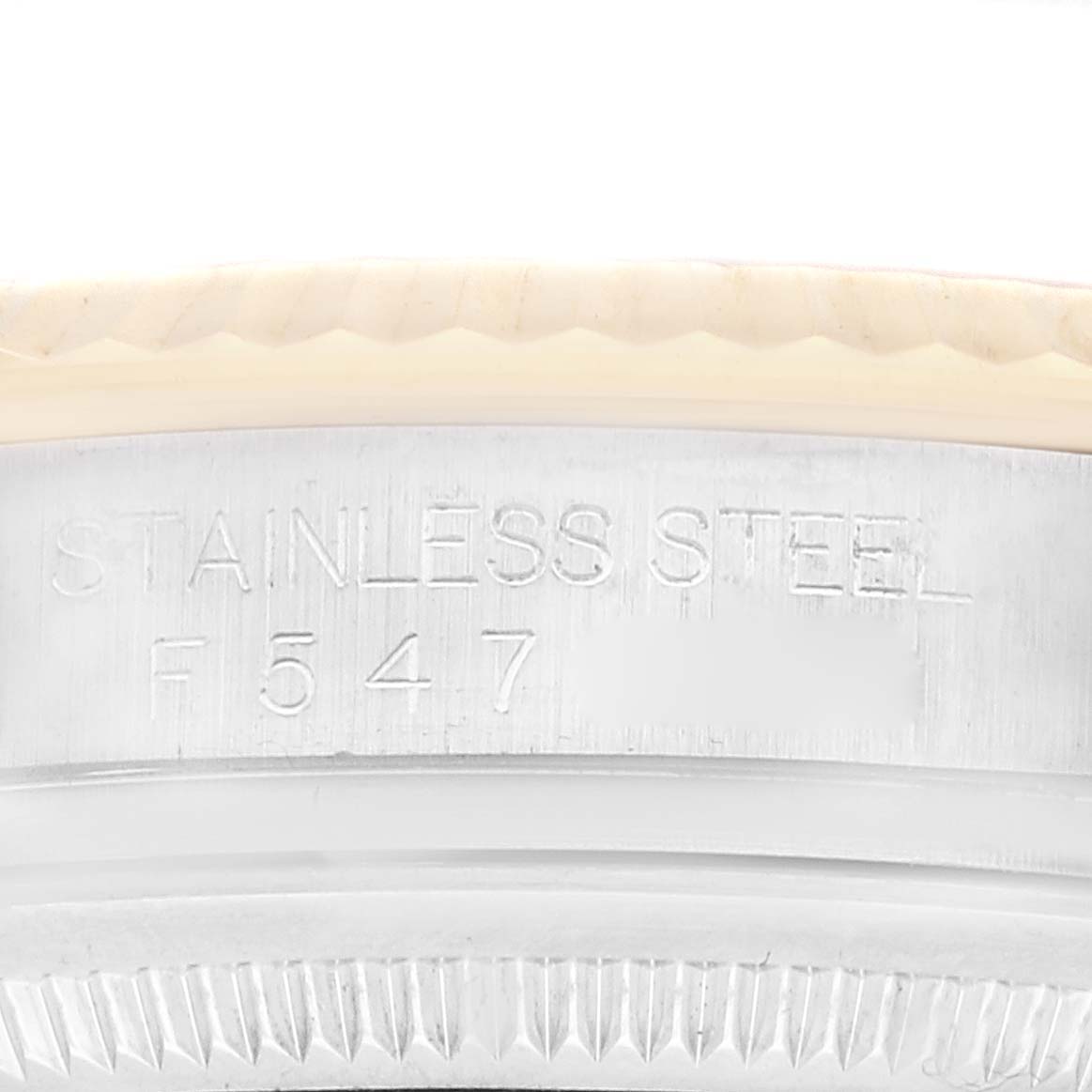 The image shows a close-up of the outer rim of the Rolex Datejust 116233 Men's Steel and Gold (two tone) Champagne Dial 116233 Men's Steel and Gold (two tone) Champagne Dial caseback, displaying "Stainless Steel" and a serial number.