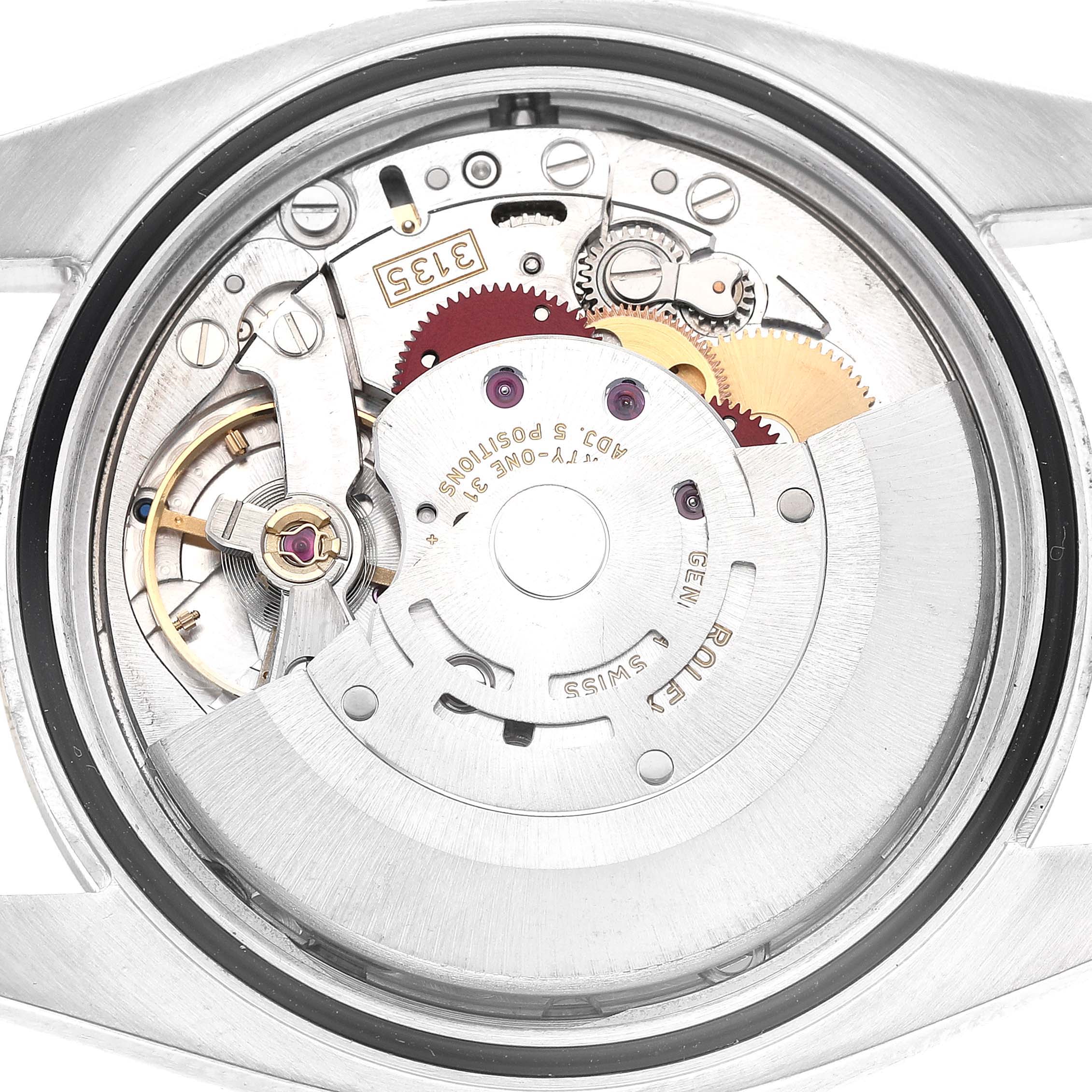The image shows the movement mechanism of a Rolex Datejust 116233 Men's Stainless Steel Silver Dial watch from the back, highlighting gears and components.
