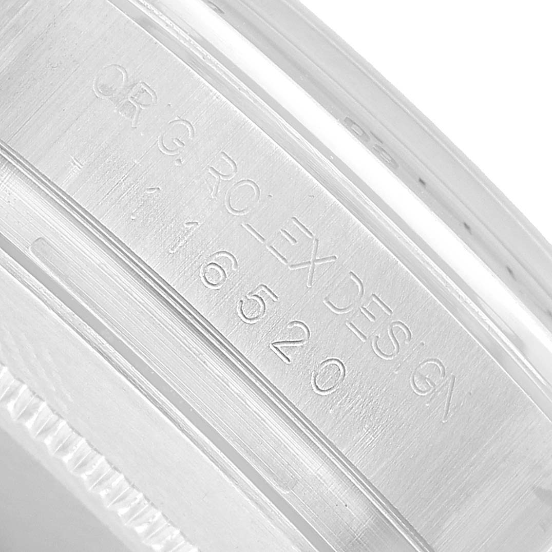 The image shows a close-up of the case edge and engraved design number on a Rolex Daytona 116520 Men's Stainless Steel Black Dial watch.