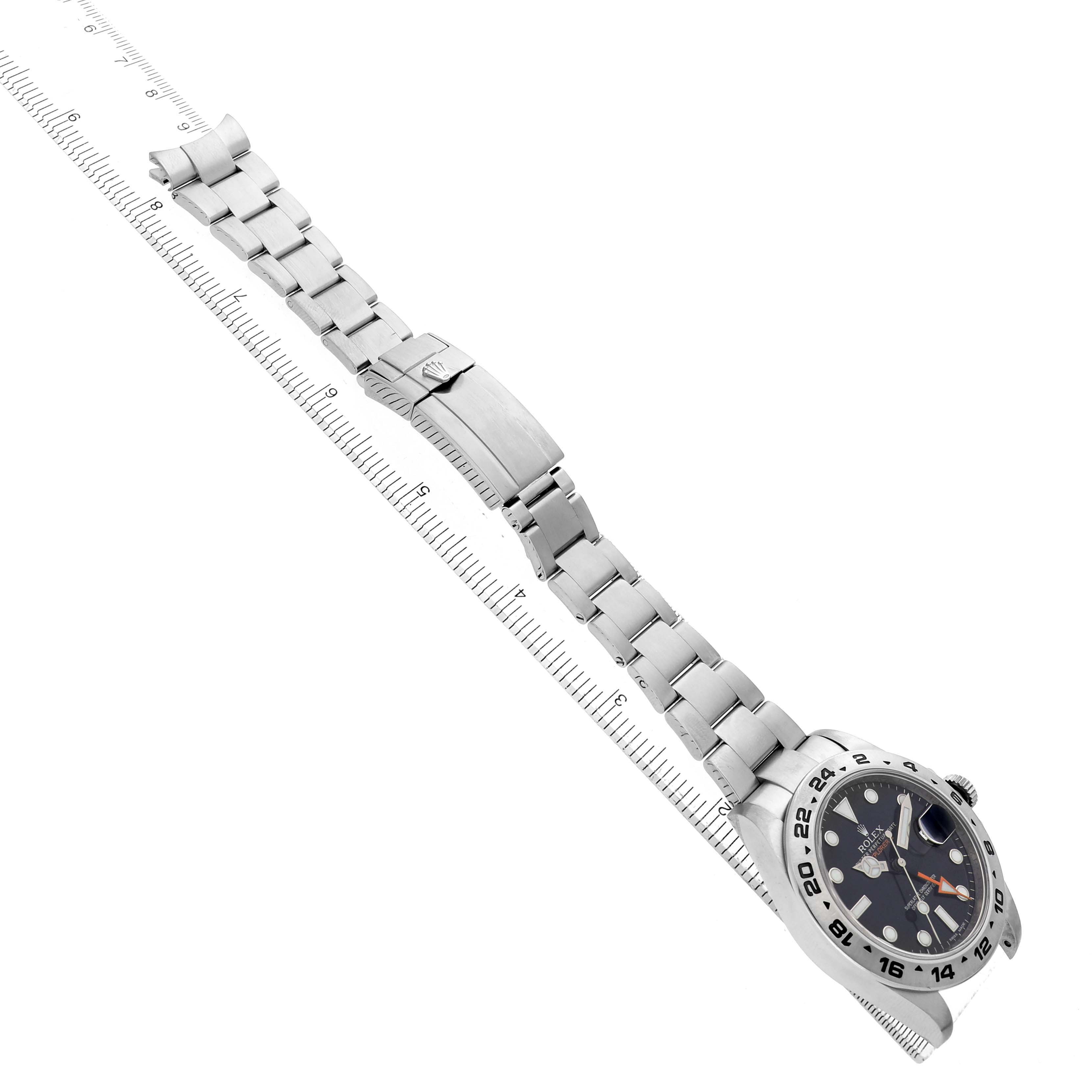 The image shows a Rolex Explorer 216570 Men's Stainless Steel Black Dial watch from a top side angle, highlighting the dial, bezel, and full bracelet along a ruler.