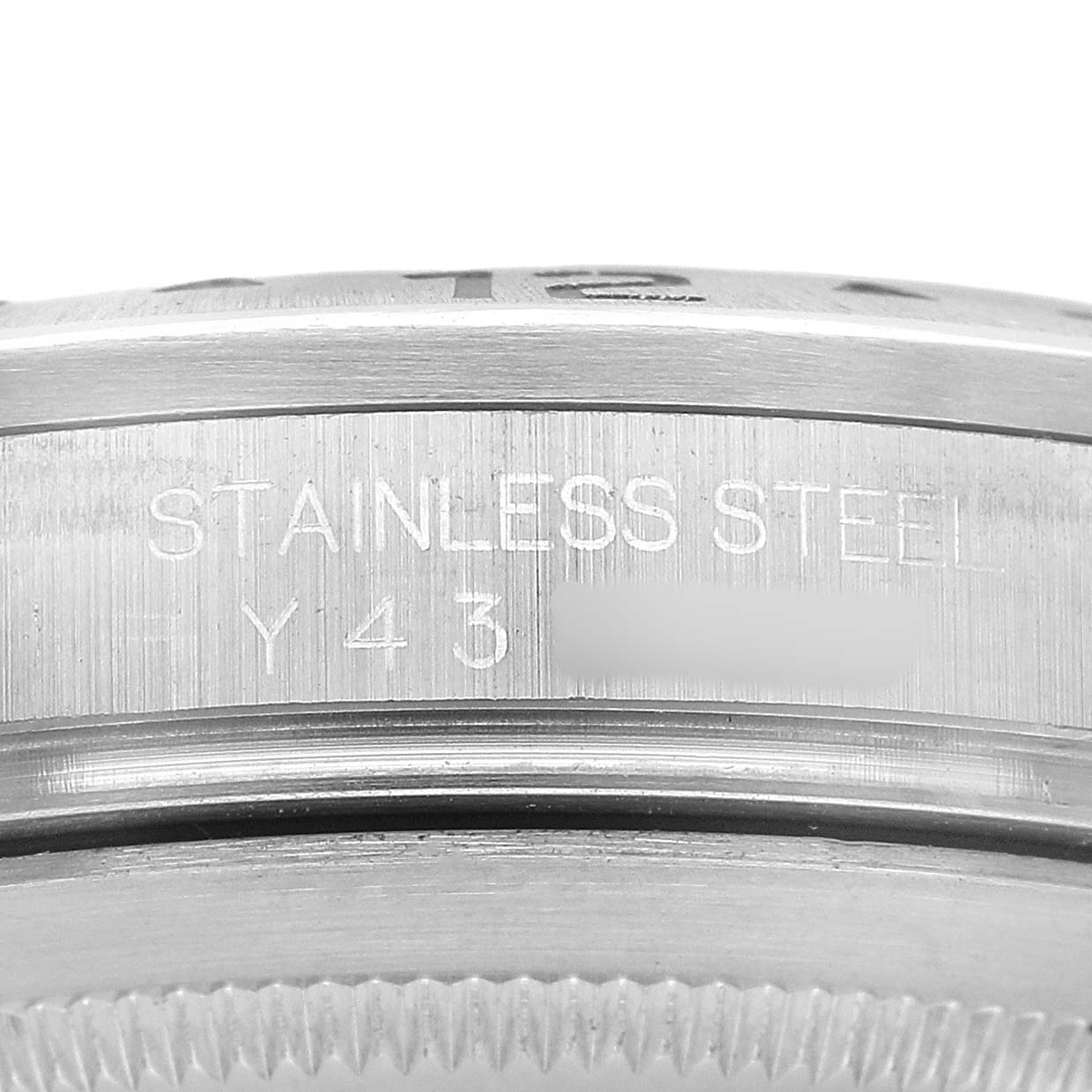 The image shows a close-up side angle of a Rolex Explorer 16570 Men's Stainless Steel White Dial watch case, highlighting the "STAINLESS STEEL" engraving.