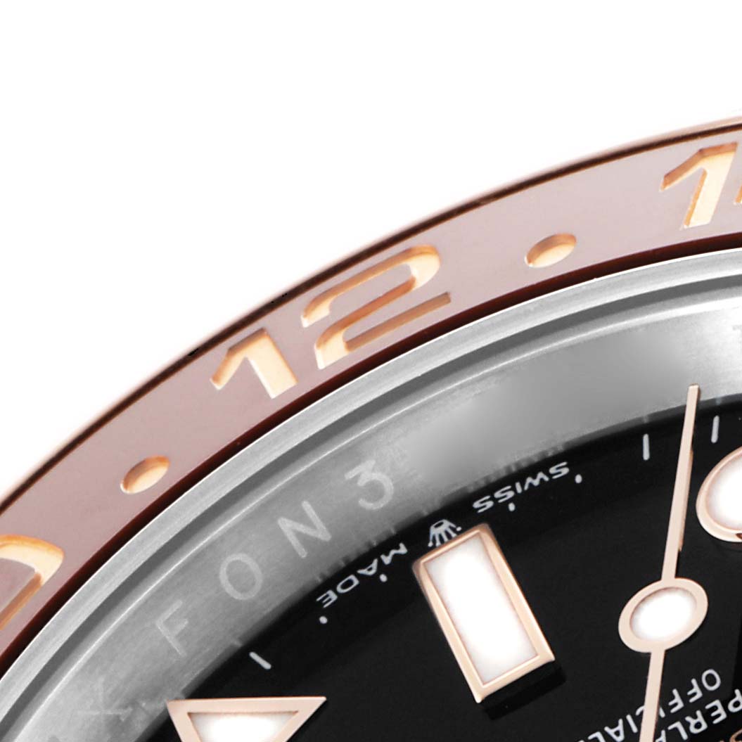 The image shows a close-up of the bezel, markers, and hands of a Rolex GMT-Master 126711 Men's Steel and Gold (two tone) Black Dial watch.