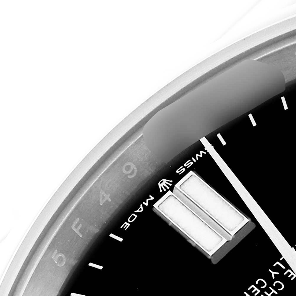 The close-up image shows a portion of the dial and bezel of a Rolex Oyster Perpetual 124300 Men
s Stainless Steel Black Dial 124300 Men
s Stainless Steel Black Dial watch, including hour markers and part of the "Swiss Made" text.