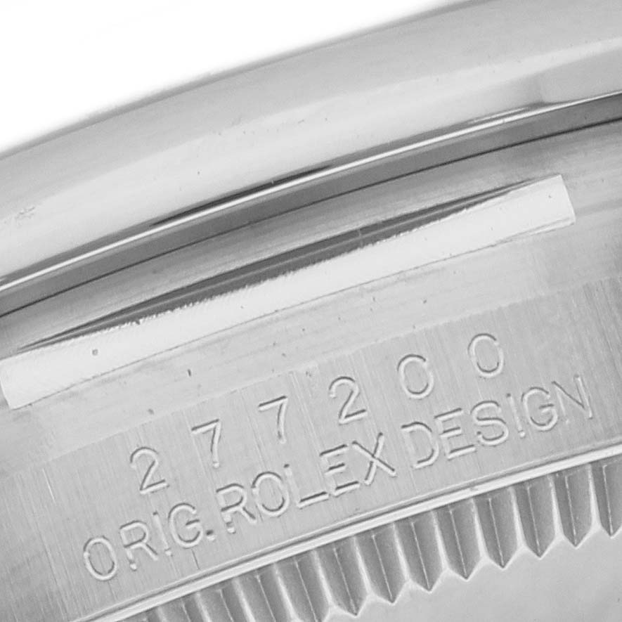 This image shows a close-up view of the Rolex Mid-Size 277200 Women's Stainless Steel Blue Dial 277200 Women's Stainless Steel Blue Dial model's case with its serial number and "ORIG. ROLEX DESIGN" engraving.
