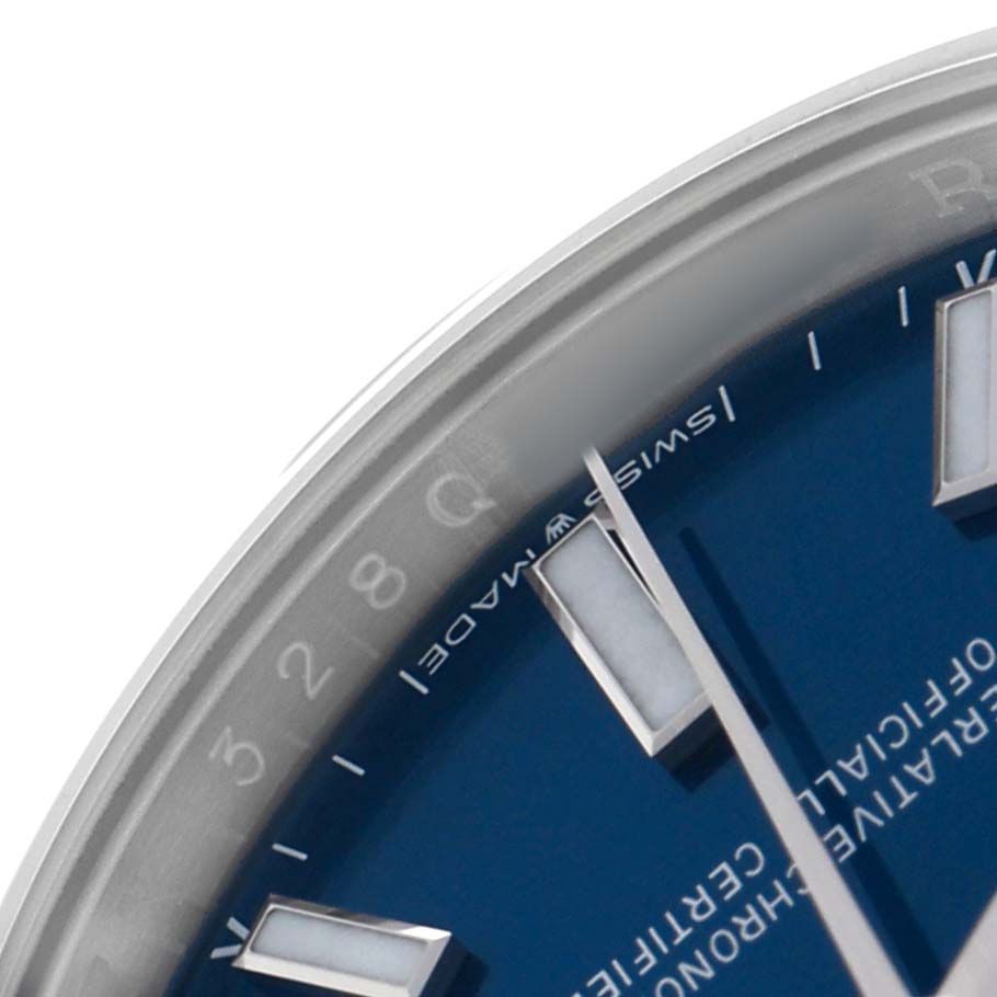 The image shows a close-up of the dial and markers of a Rolex Oyster Perpetual 124200 Men's Stainless Steel Blue Dial watch at an angle.