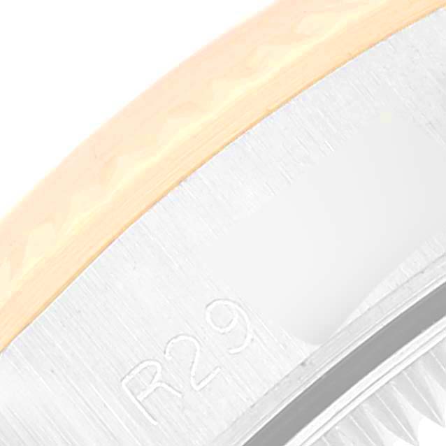 This close-up image of a Rolex Oyster Perpetual 67193 Women's Steel and Gold (two tone) Silver Dial 67193 Women's Steel and Gold (two tone) Silver Dial watch shows part of the bezel and the engraved chapter ring.