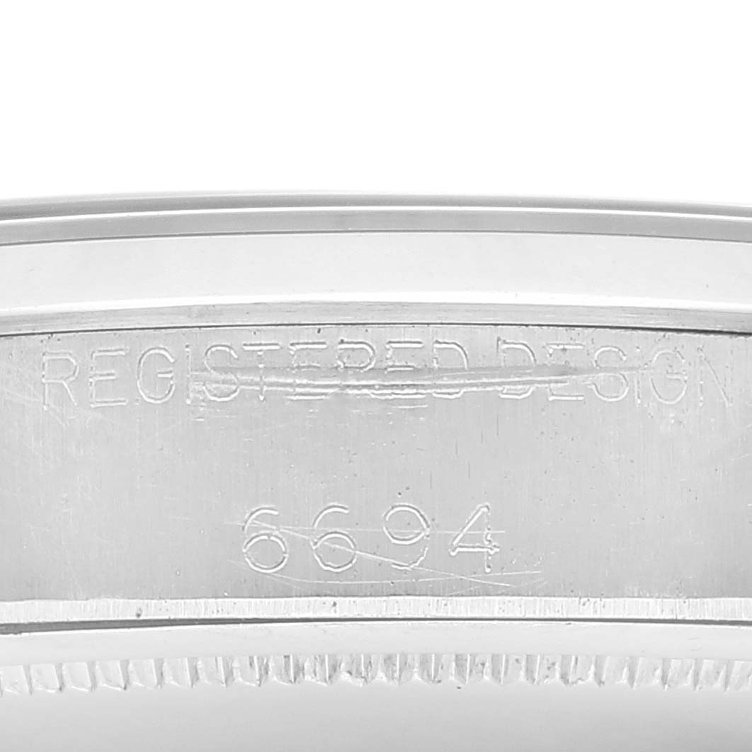 This close-up image shows the engraved case back of the Rolex Vintage Collection 6694 Men's Stainless Steel Black Dial 6694 Men's Stainless Steel Black Dial model, highlighting the "REGISTERED DESIGN" and "6694" markings.