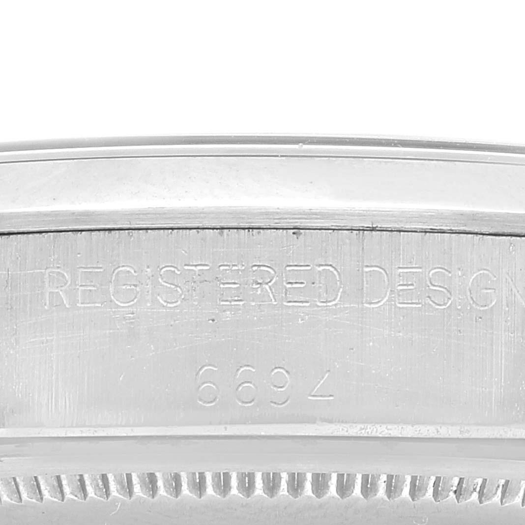 The image displays a close-up view of the caseback edge of a Vintage Collection Rolex watch, showing the serial and design numbers.