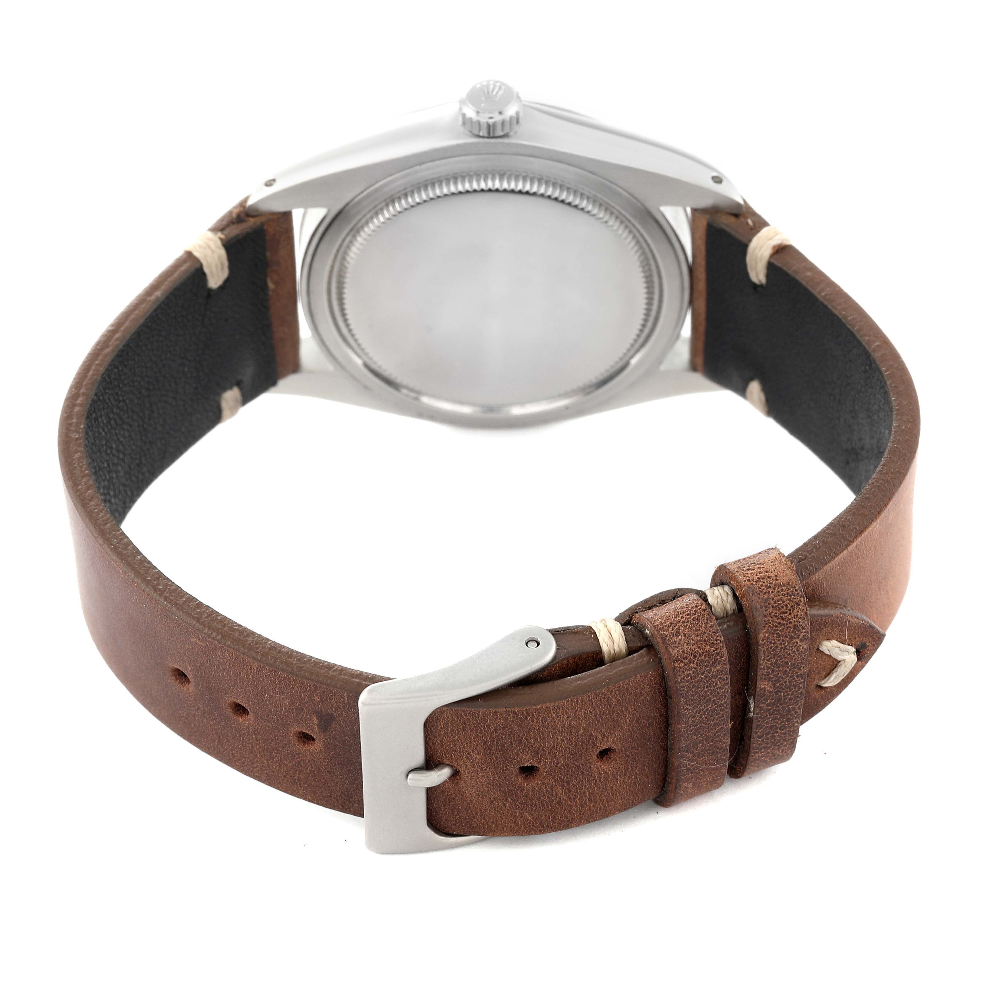 The image shows the back view of a Rolex Vintage Collection 6694 Men
s Stainless Steel Silver Dial 6694 Men
s Stainless Steel Silver Dial watch, focusing on the case back and brown leather strap with buckle.