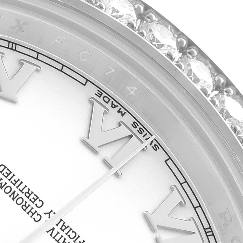 The image shows a close-up of the Rolex President 218349 Men's White Gold White Dial's bezel and part of the dial, featuring Roman numerals and diamond accents.