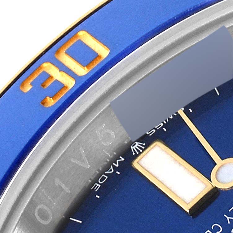 This image shows a close-up of the bezel and part of the dial on a Rolex Submariner 126613LB Men
s Steel and Gold (two tone) Blue Dial 126613LB Men
s Steel and Gold (two tone) Blue Dial watch.