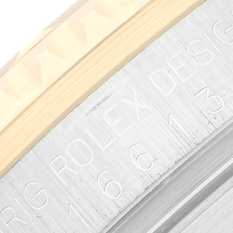 The image shows a close-up angle of the side of a Rolex Submariner 16613 Men
s Steel and Gold (two tone) Blue Dial 16613 Men
s Steel and Gold (two tone) Blue Dial watch case, revealing engraved text including the model number.