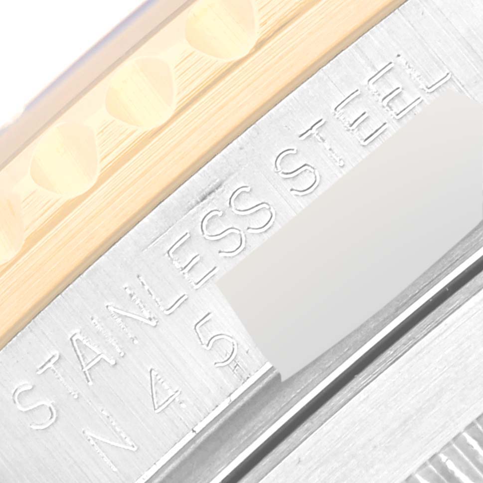 The image shows a close-up angle of the bezel and case side of a Rolex Submariner 16613 Men
s Steel and Gold (two tone) Blue Dial 16613 Men
s Steel and Gold (two tone) Blue Dial, highlighting the "STAINLESS STEEL" engraving.