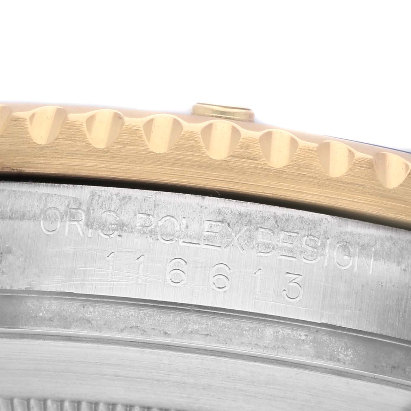The image shows a close-up of the Rolex Submariner 116613F Men's Steel and Gold (two tone) Blue Dial's engraved case side and bezel edge.