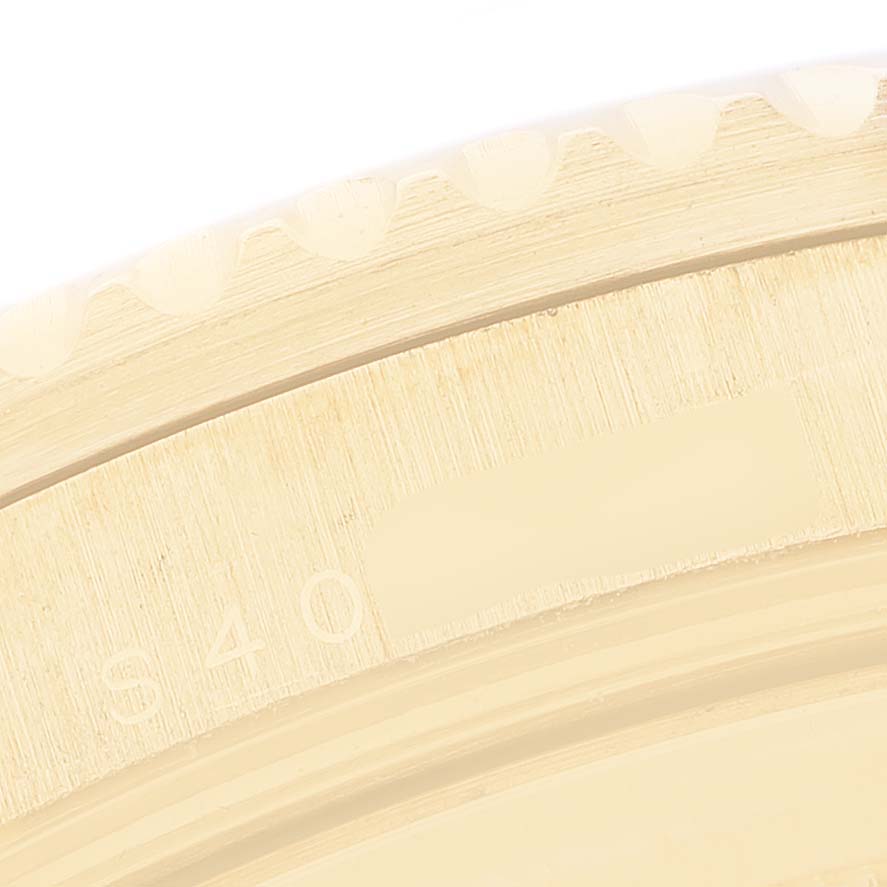 The image shows a detailed close-up of the gold bezel edge of a Rolex Submariner 16618 Men's Yellow Gold Blue Dial watch.
