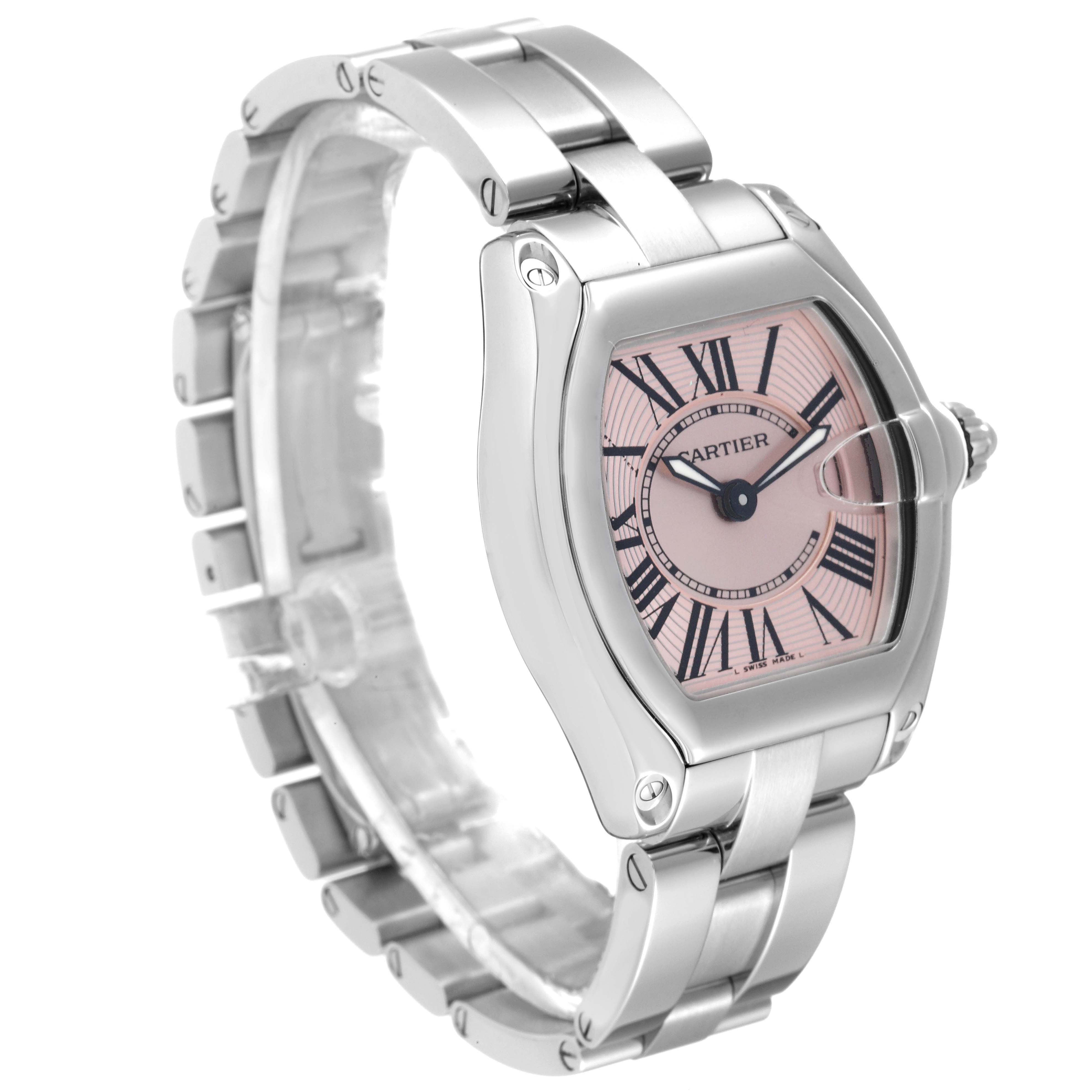 This image shows a Cartier Roadster W62017V3 Women's Stainless Steel Pink Dial W62017V3 Women's Stainless Steel Pink Dial watch at a 3/4 angle, highlighting its pink dial, Roman numerals, and stainless steel band.