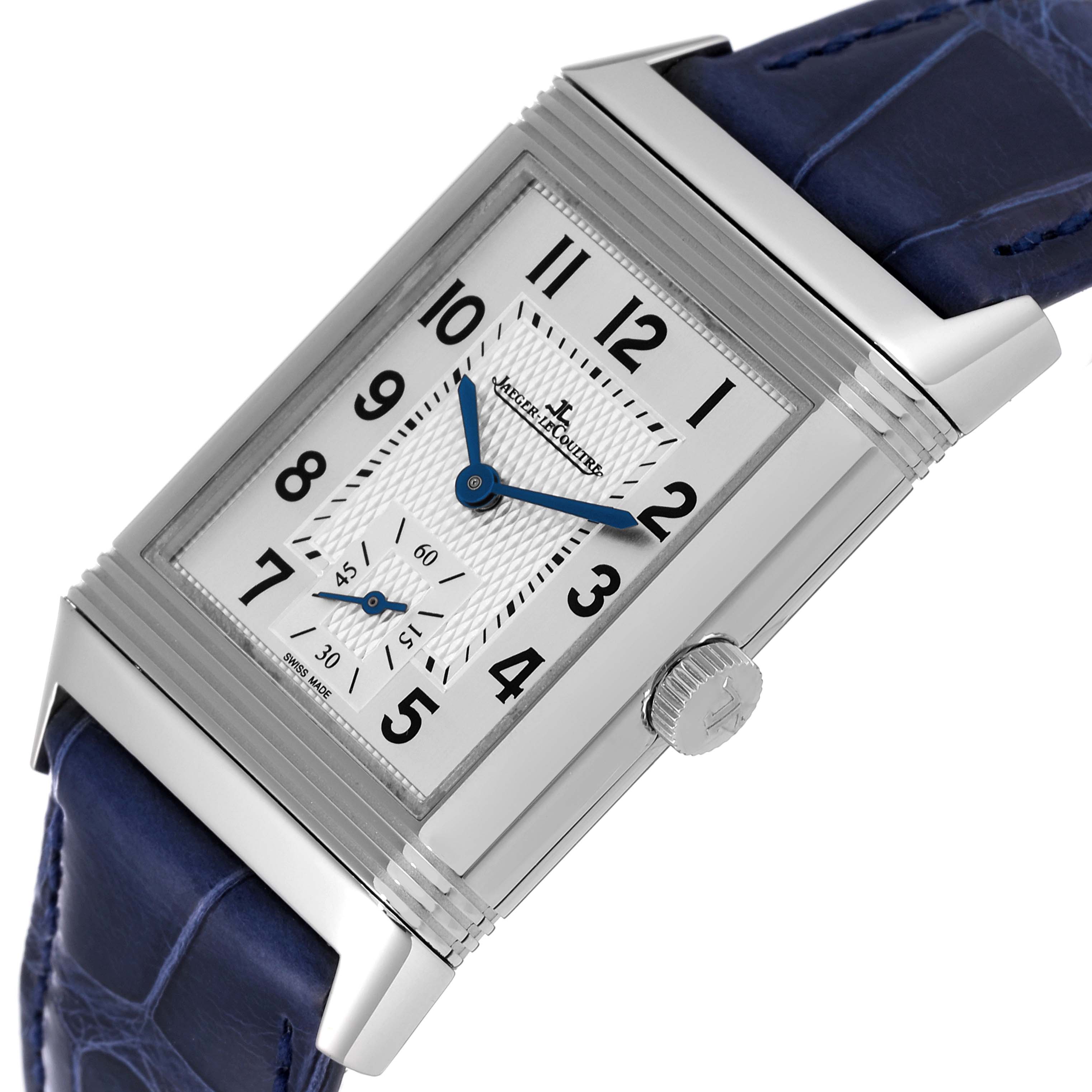 The image shows a close-up angle of the Jaeger LeCoultre Reverso Q3848420 Men's Stainless Steel Silver Dial Q3848420 Men's Stainless Steel Silver Dial watch, highlighting its rectangular dial, crown, and blue leather strap.