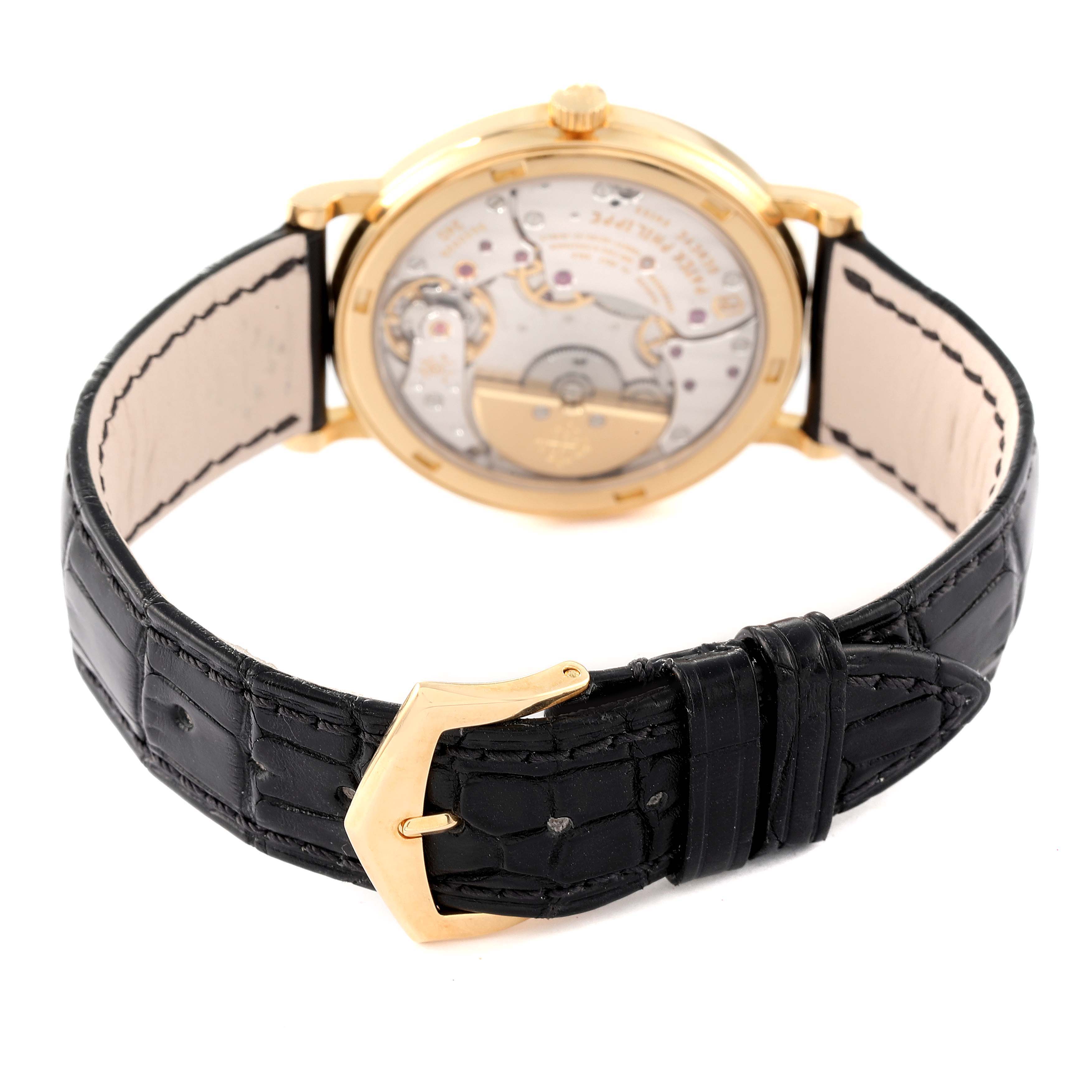 The image shows the back view of a Patek Philippe Calatrava 5120J Men's Yellow Gold White Dial 5120J Men's Yellow Gold White Dial watch, highlighting its movement and black leather strap with a gold buckle.