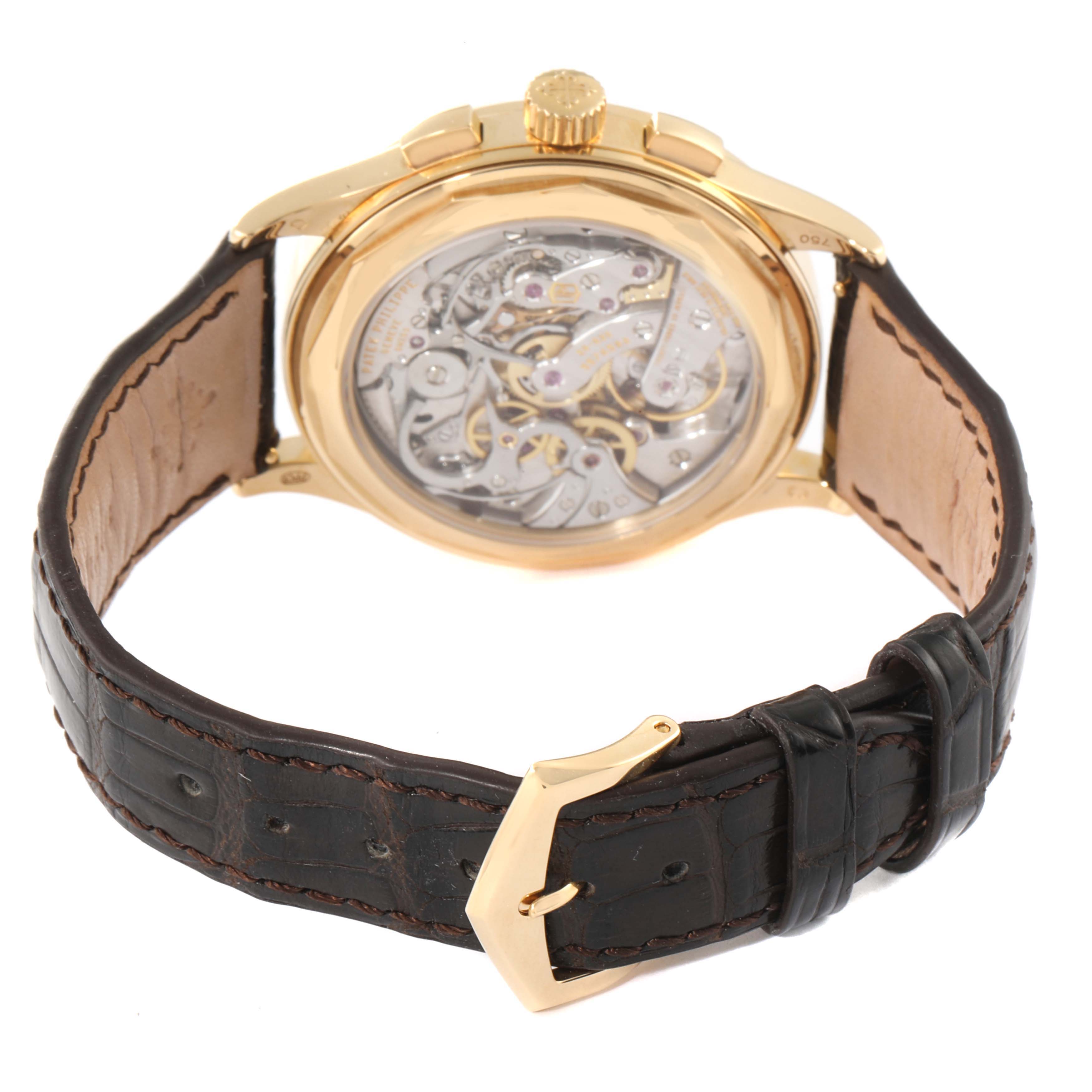 The image shows the back view of the Patek Philippe Complications 5170J Men's Yellow Gold Silver Dial 5170J Men's Yellow Gold Silver Dial watch, highlighting its intricate movement and leather strap.