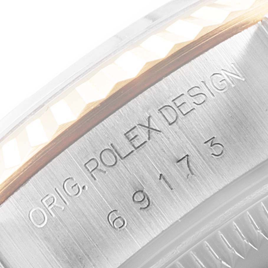 This close-up image shows the side view of a Rolex Datejust 69173 Women
s Steel and Gold (two tone) Champagne Dial 69173 Women
s Steel and Gold (two tone) Champagne Dial watch, focusing on the engraved serial number and design details.