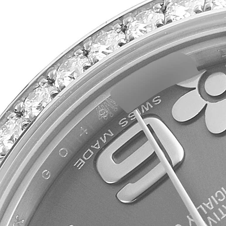 The image shows a close-up of the bezel and part of the dial of a Rolex Mid-Size 178384 Women's Stainless Steel Grey Dial 178384 Women's Stainless Steel Grey Dial model watch with diamond settings.