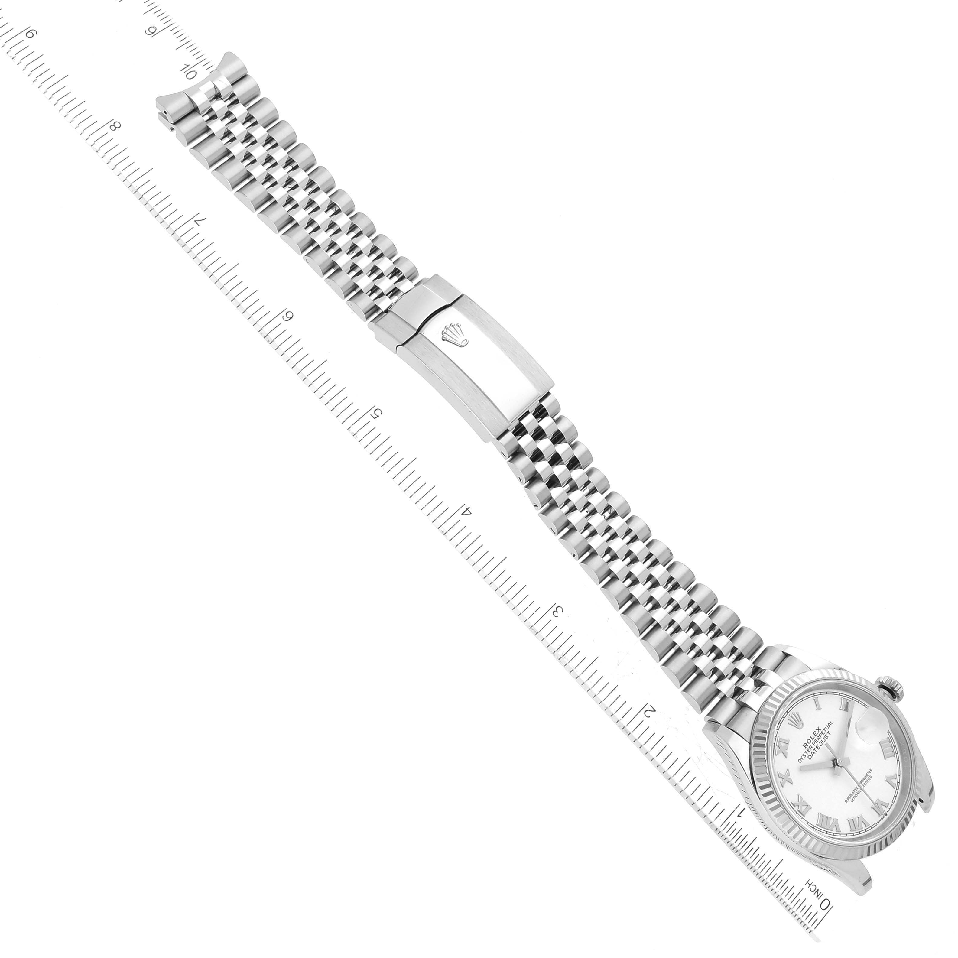 The image shows a Rolex Datejust 126234 Men's Stainless Steel White Dial 126234 Men's Stainless Steel White Dial watch from a top view, highlighting the face, bracelet, and clasp next to a ruler.