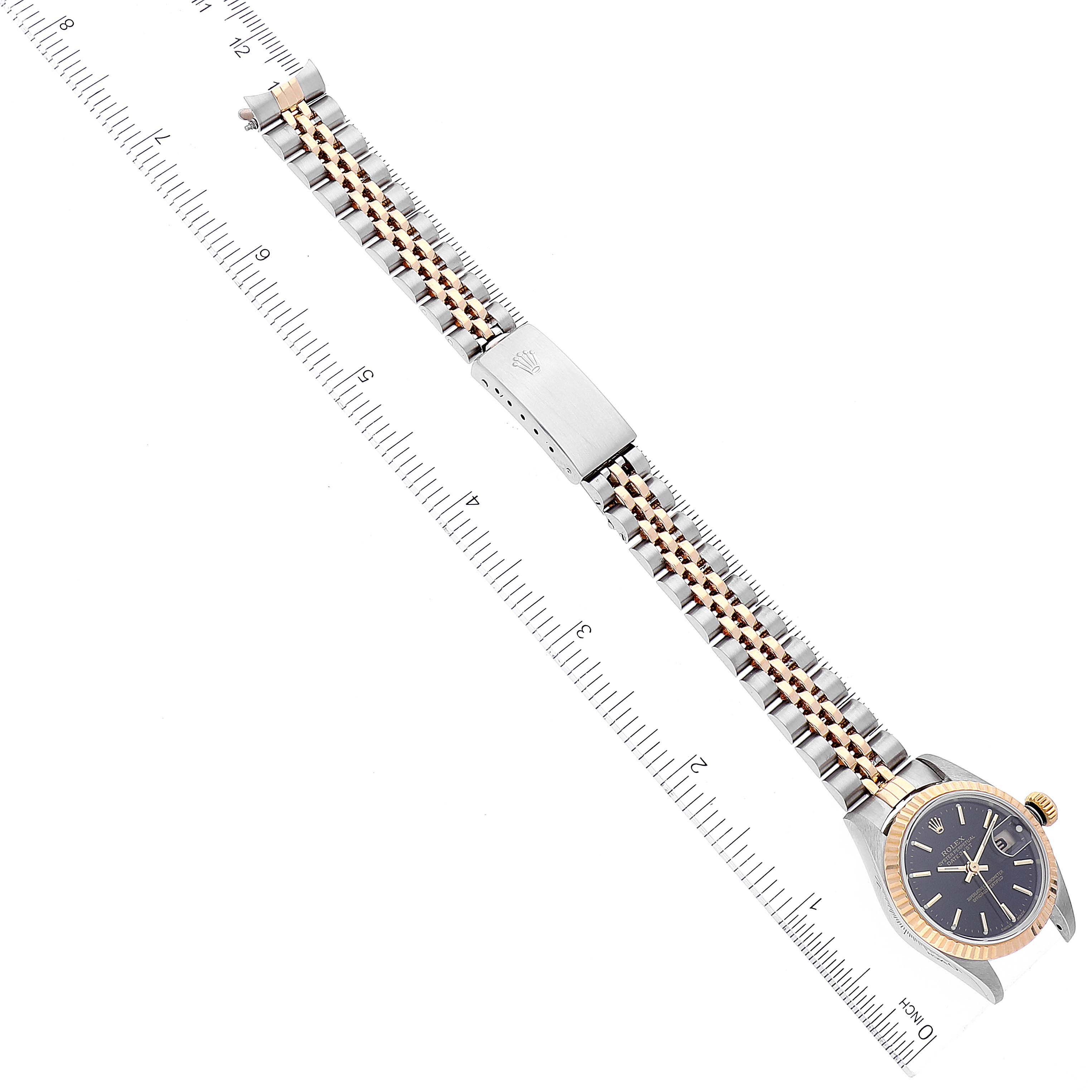 The image shows a Rolex Datejust 79173 Women's Steel and Gold (two tone) Black Dial 79173 Women's Steel and Gold (two tone) Black Dial watch laid flat, displaying its bracelet, clasp, and watch face, measured against a ruler.