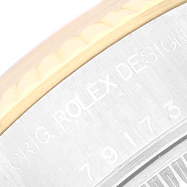 The image shows a close-up of the outer rim and part of the case back of a Rolex Datejust 79173 Women's Steel and Gold (two tone) Black Dial 79173 Women's Steel and Gold (two tone) Black Dial watch, highlighting the engraving.